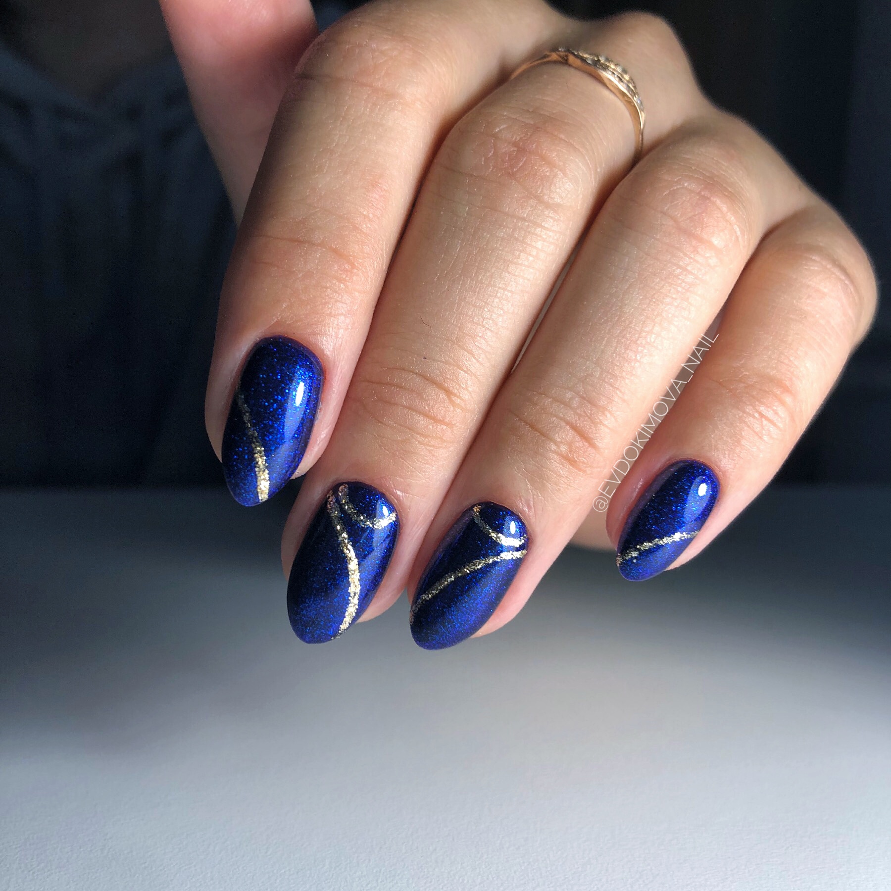 Маникюр с серебряными полосками в синем цвете на короткие ногти.