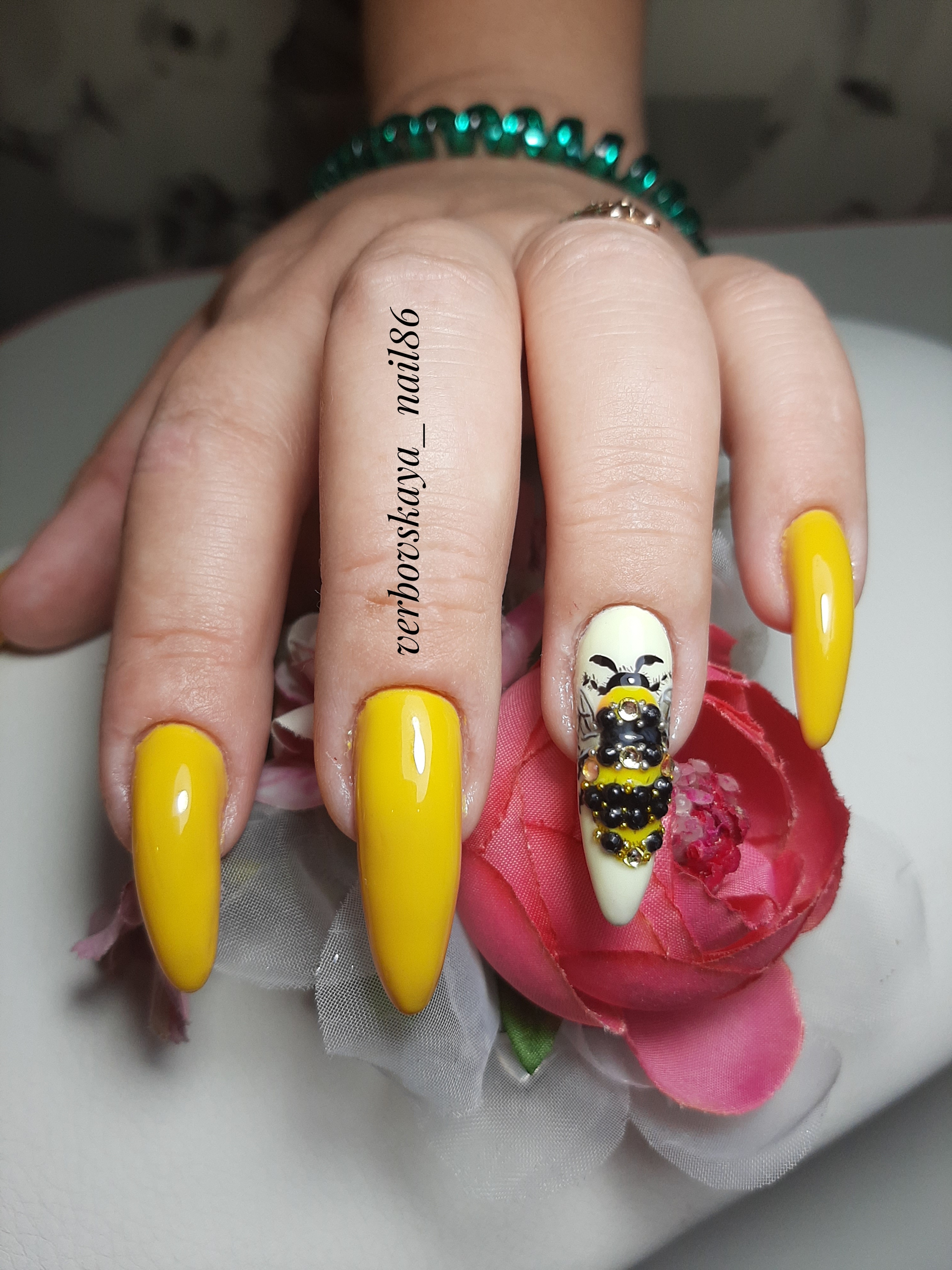 Маникюр с пчелой и стразами в желтом цвете на длинные ногти.