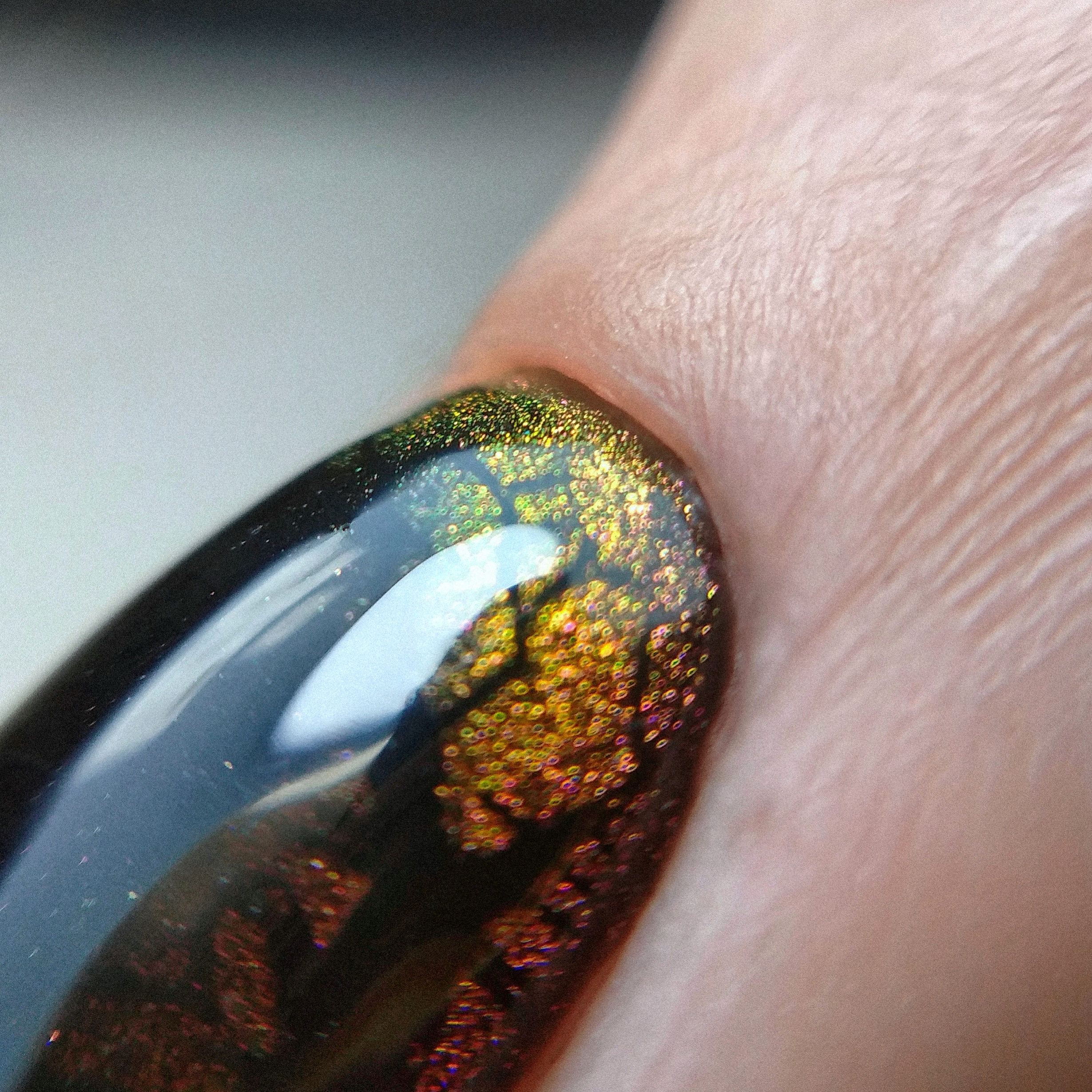 Маникюр в чёрном цвете с золотым эффектом кошачий глаз.