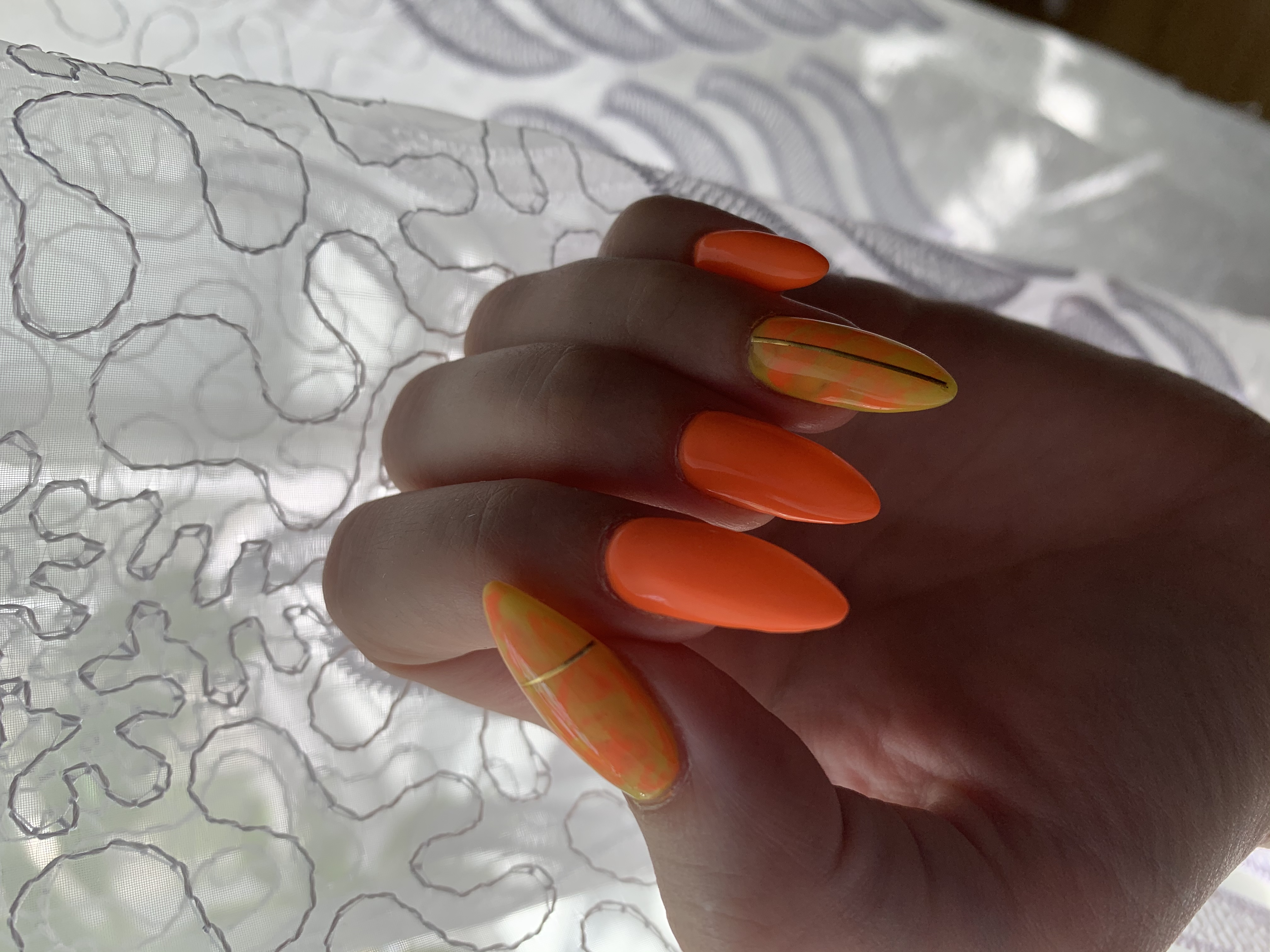 Маникюр с золотыми полосками в оранжевом цвете на длинные ногти.