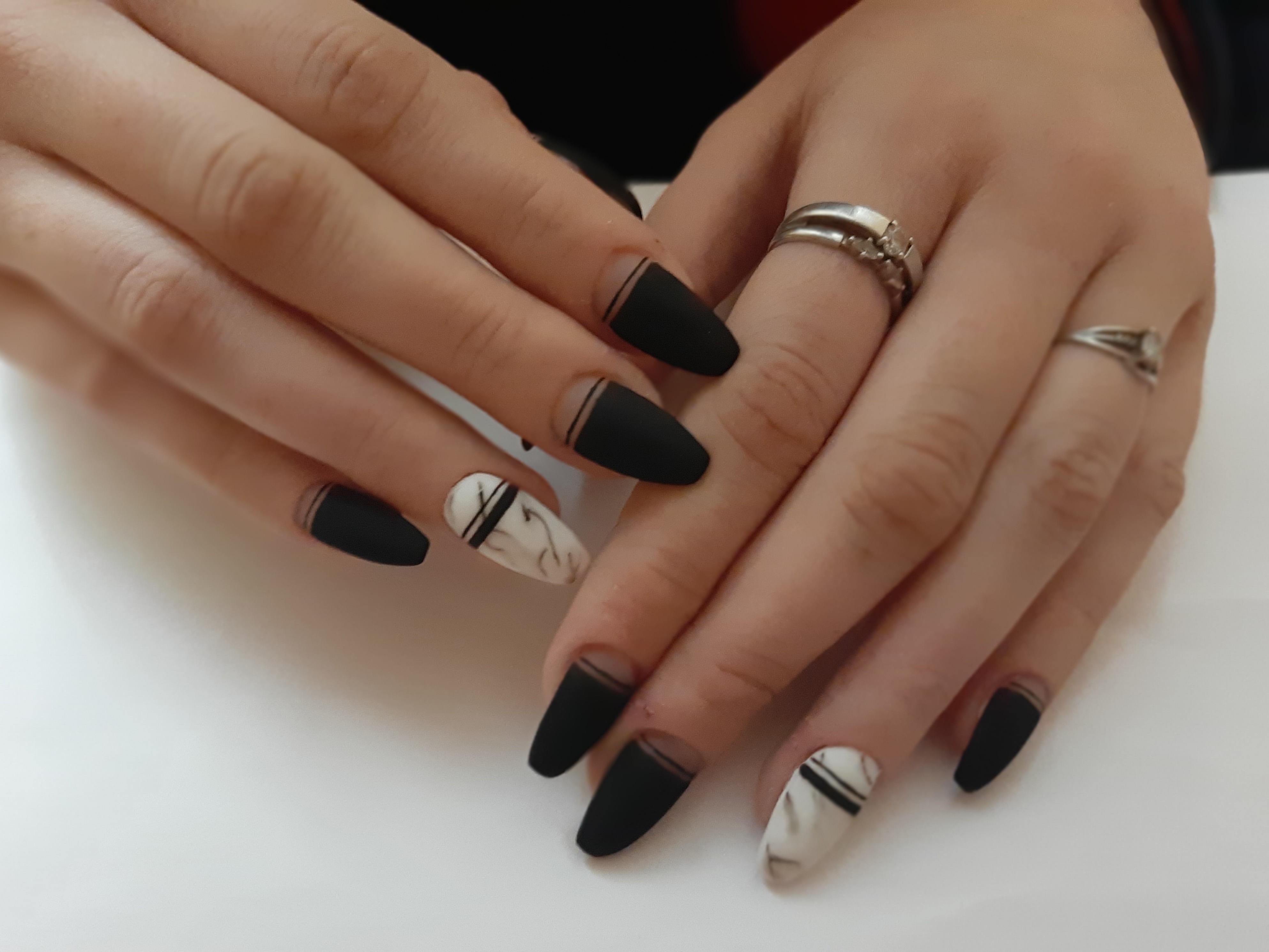 Лунный матовый маникюр с мраморным дизайном и полосками в черном цвете на длинные ногти.