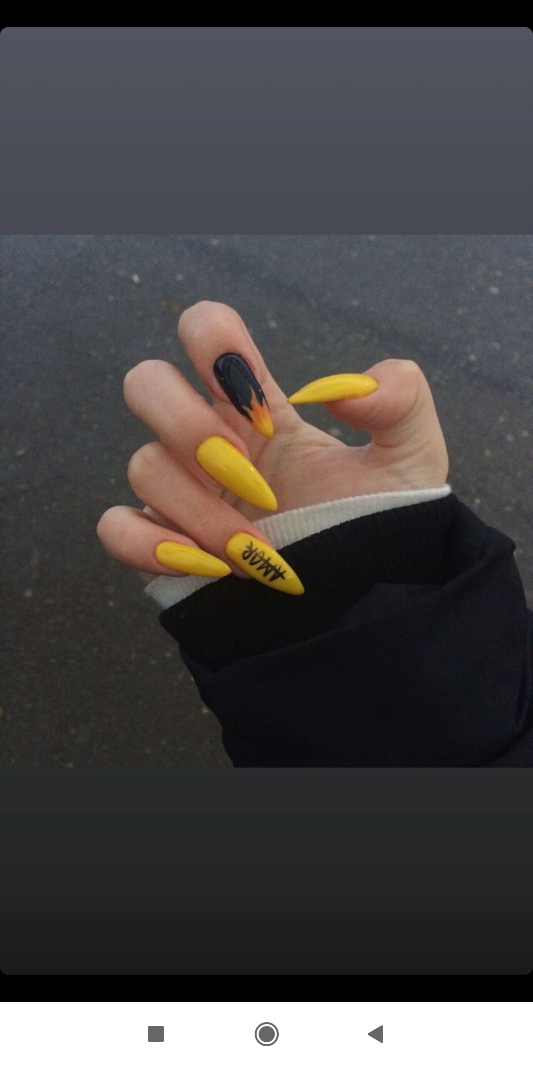 Маникюр с языками пламени и надписями в желтом цвете на длинные ногти.