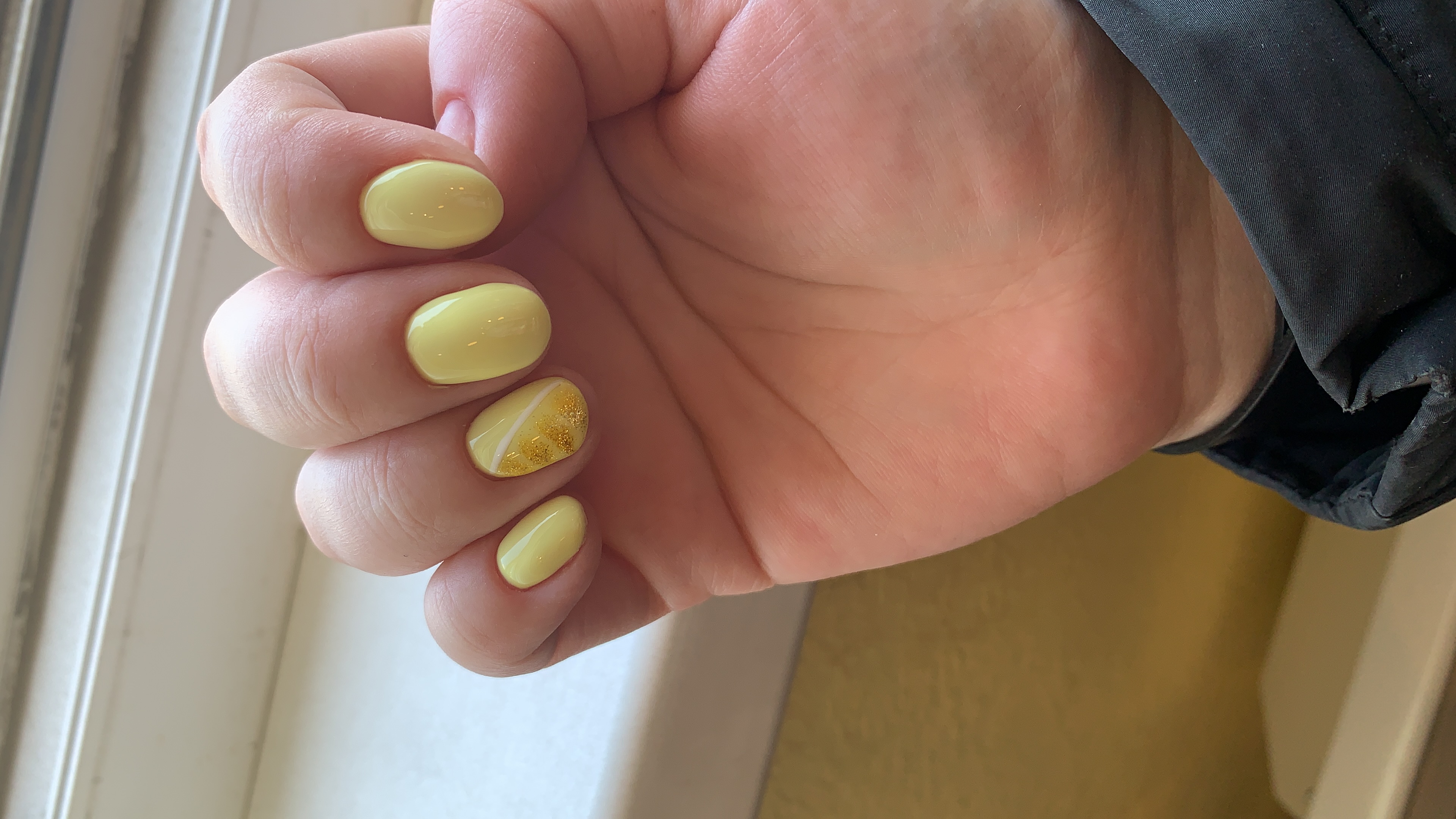 Маникюр с золотыми блестками в желтом цвете на короткие ногти.