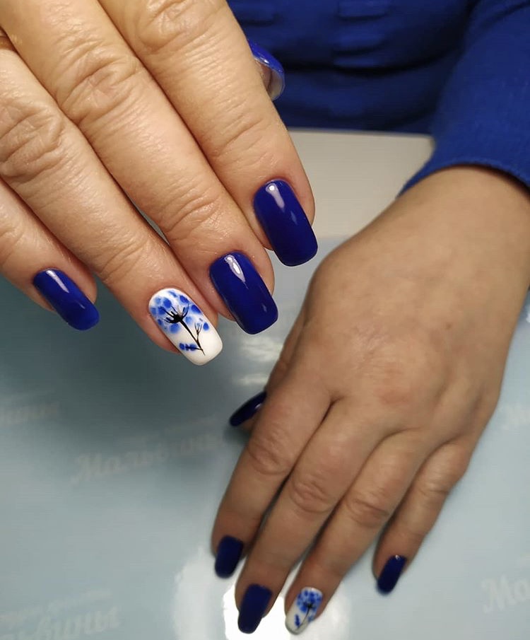 Маникюр с цветочным рисунком в синем цвете на длинные ногти.