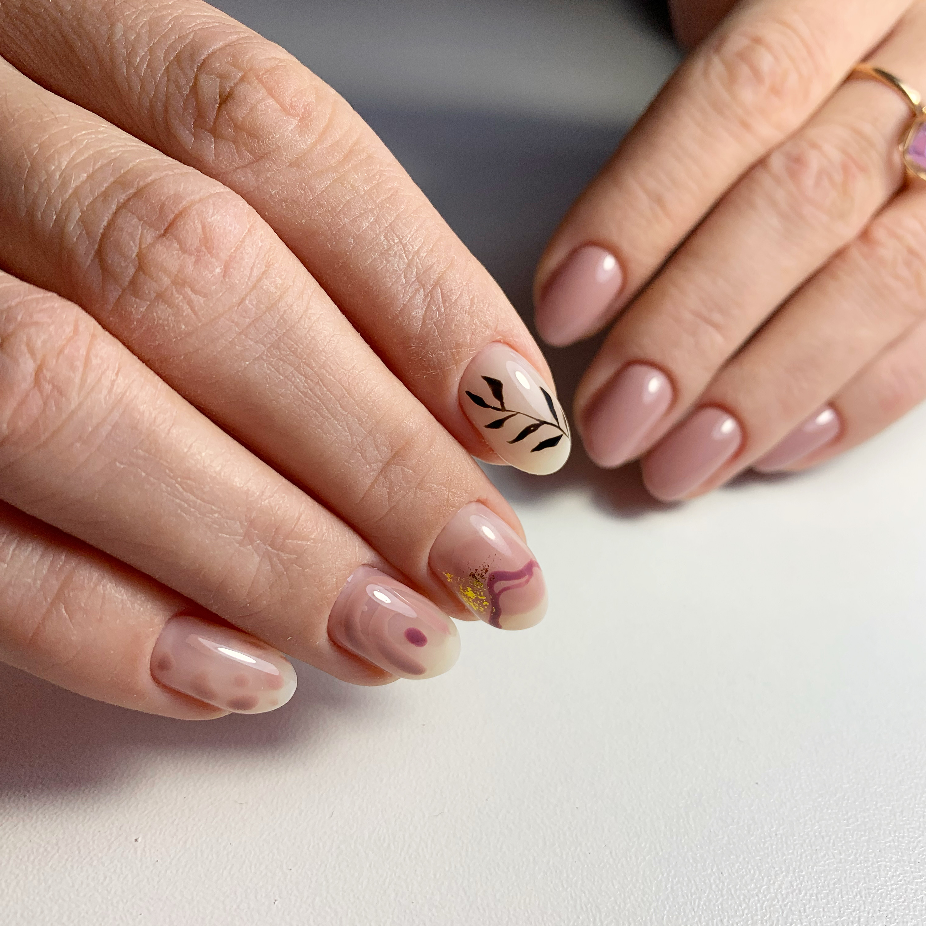 Нюдовый маникюр с растительным рисунком и золотой фольгой на короткие ногти.