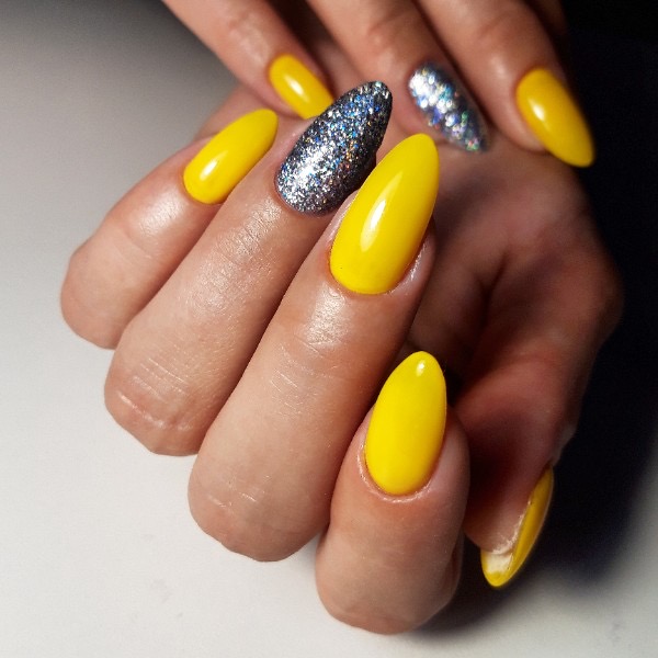 Маникюр с серебряными блестками в желтом цвете на длинные ногти.