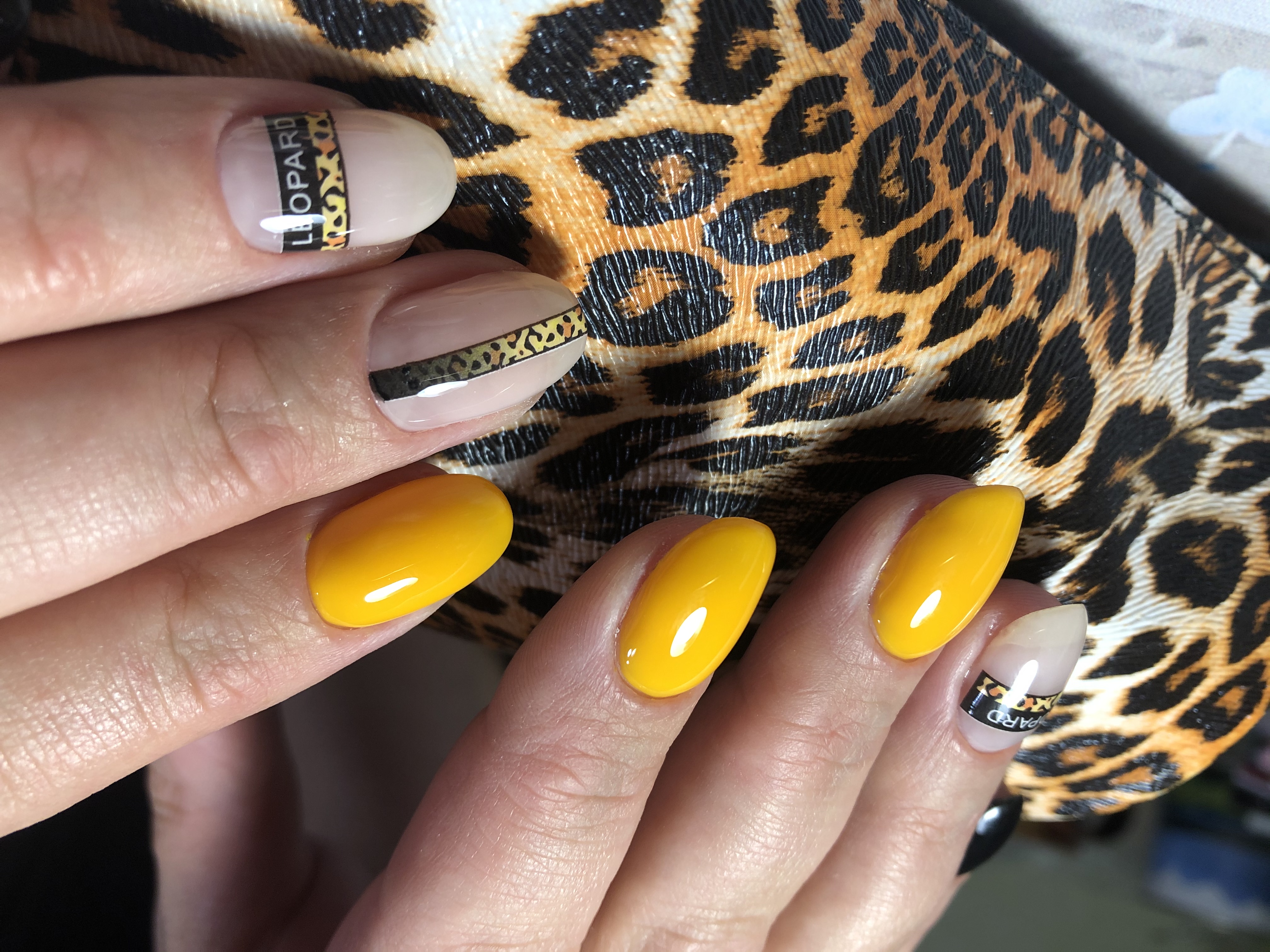 Маникюр с леопардовым принтом и надписями в желтом цвете на короткие ногти.