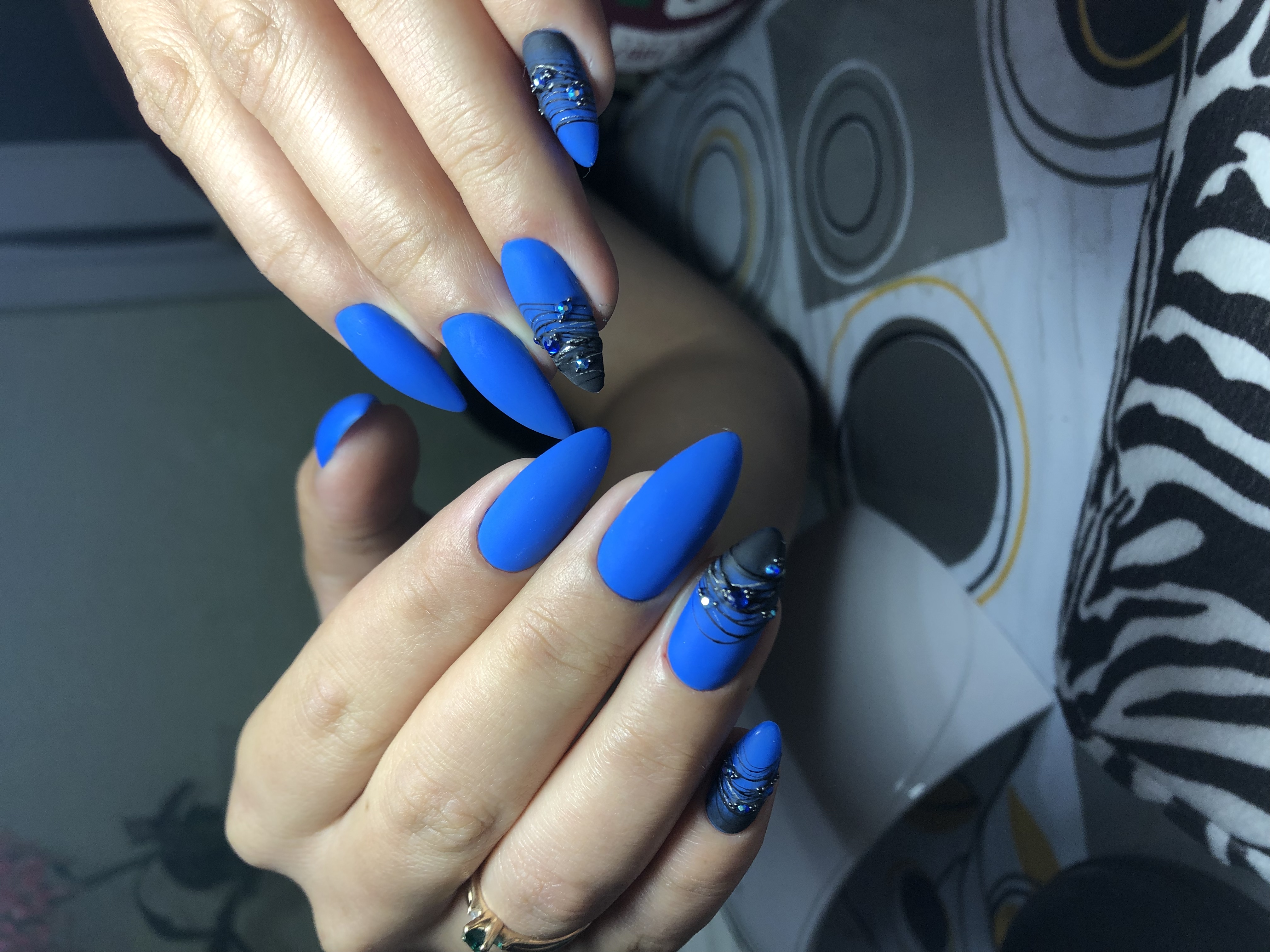Матовый маникюр с паутинкой и стразами в синем цвете на длинные ногти.