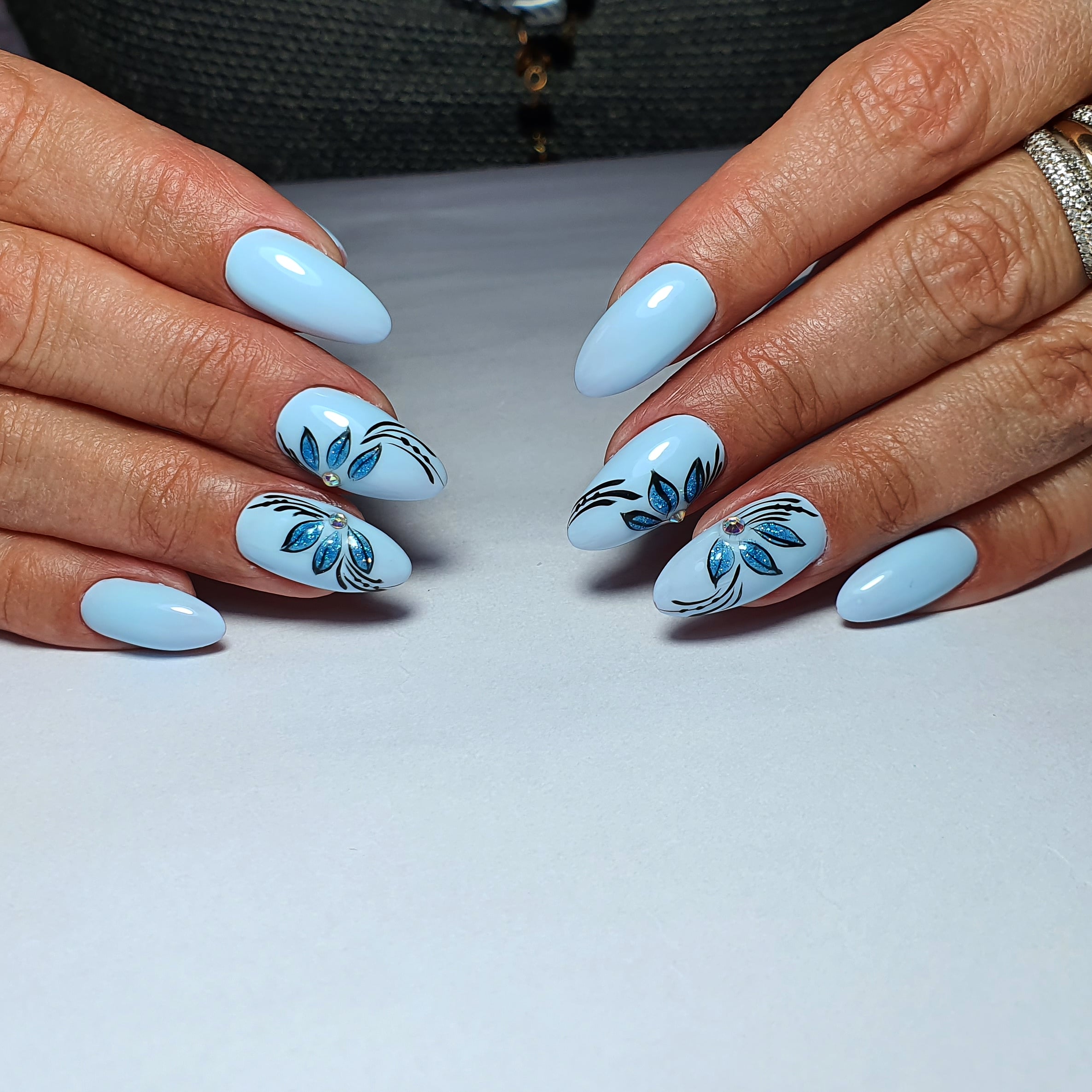 Маникюр с цветочным рисунком в голубом цвете на длинные ногти.