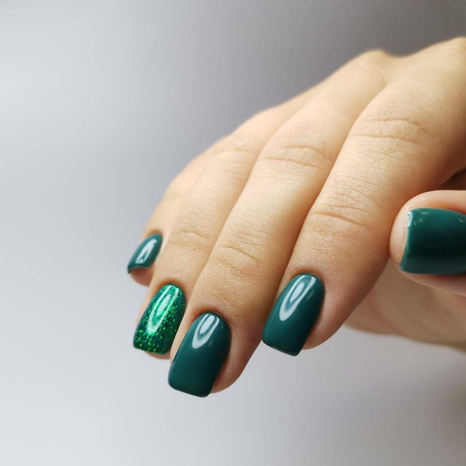 Маникюр с блестками в темно-зеленом цвете на короткие ногти.