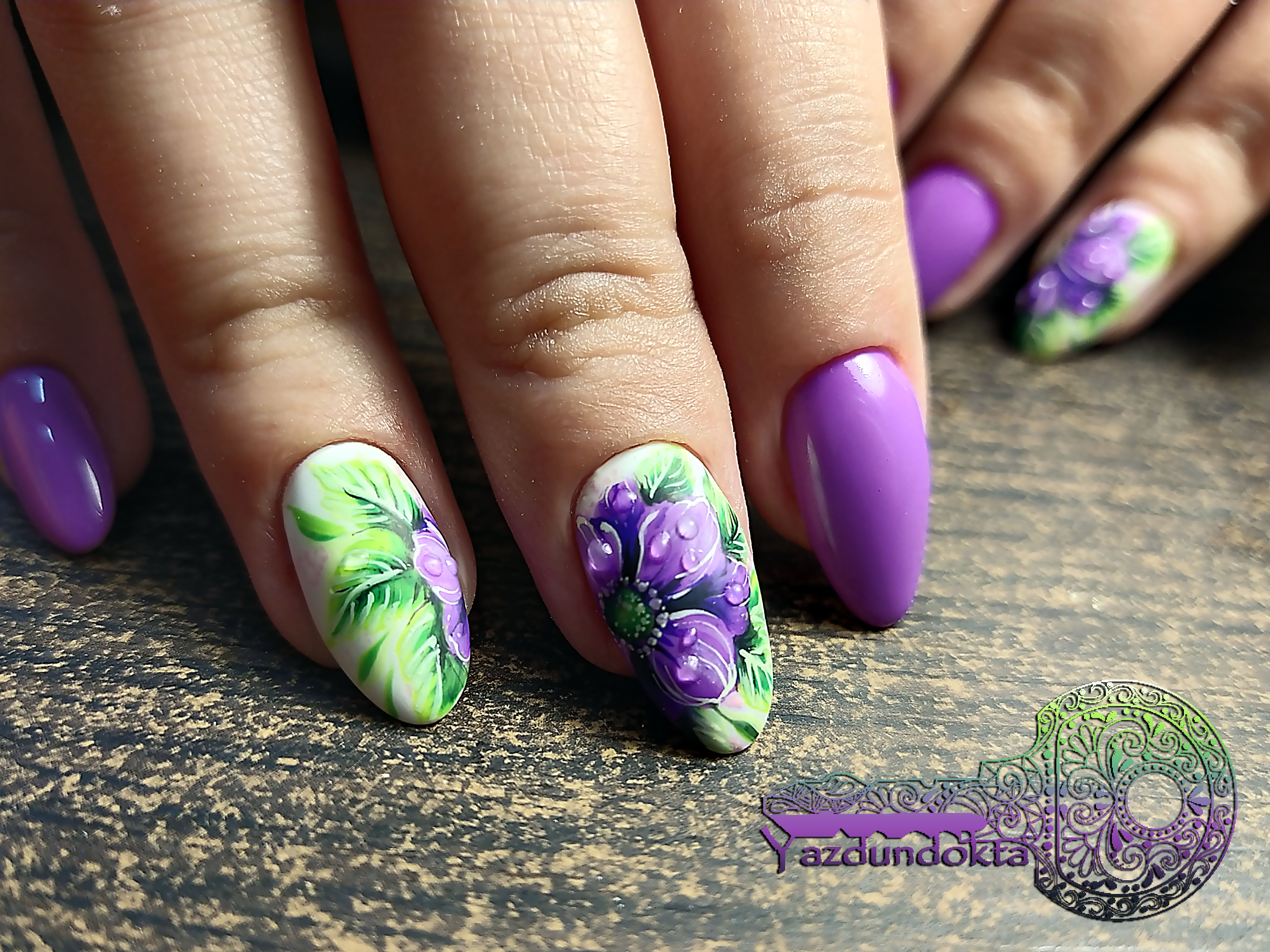 Маникюр с цветочным рисунком в фиолетовом цвете на длинные ногти.