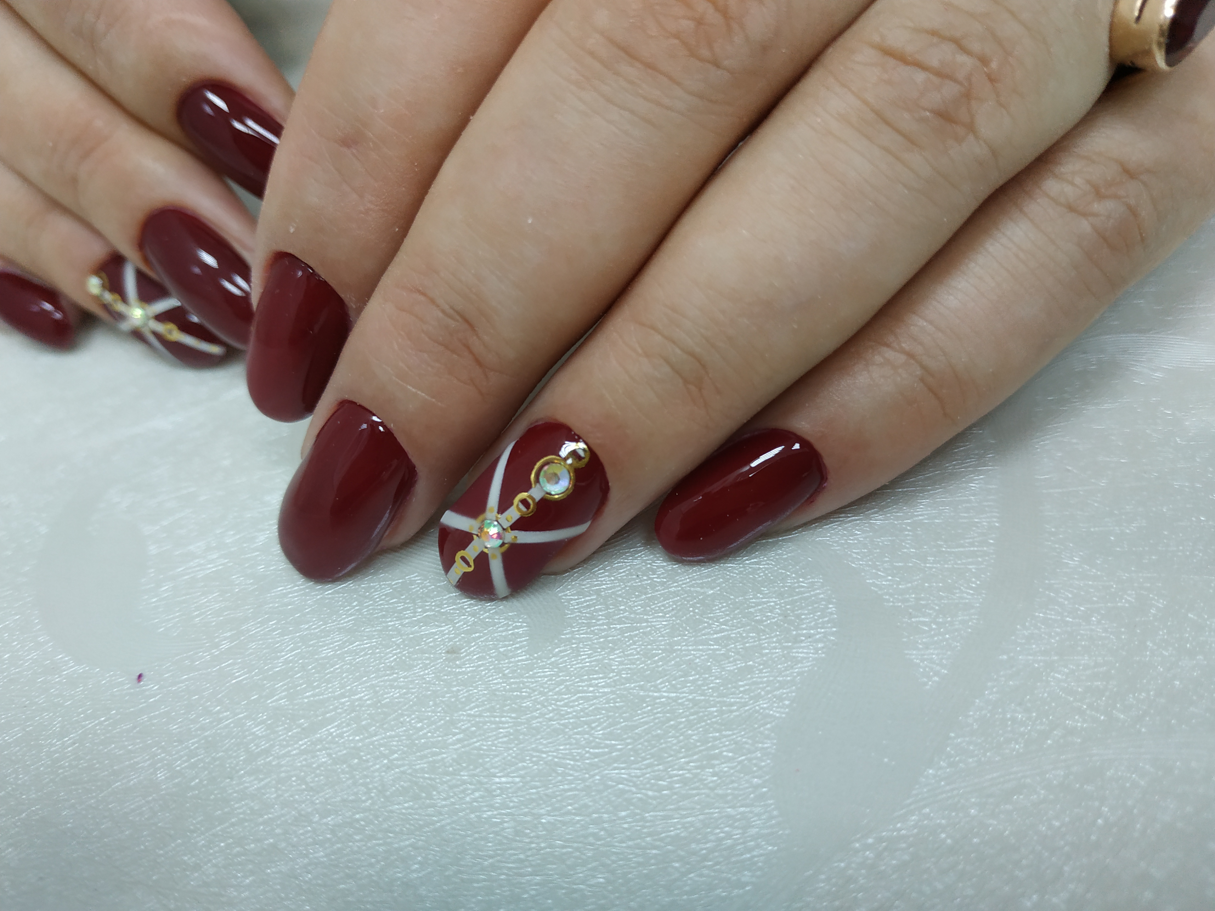 Маникюр с трендовыми слайдерами в темно-красном цвете на короткие ногти.