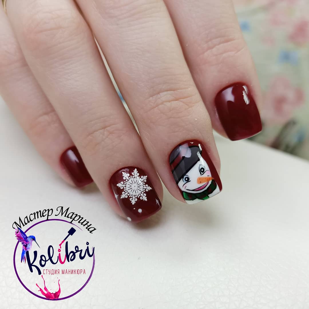 Маникюр в тёмно-красном цвете с рисунком "снеговик" и слайдером "снежинка".