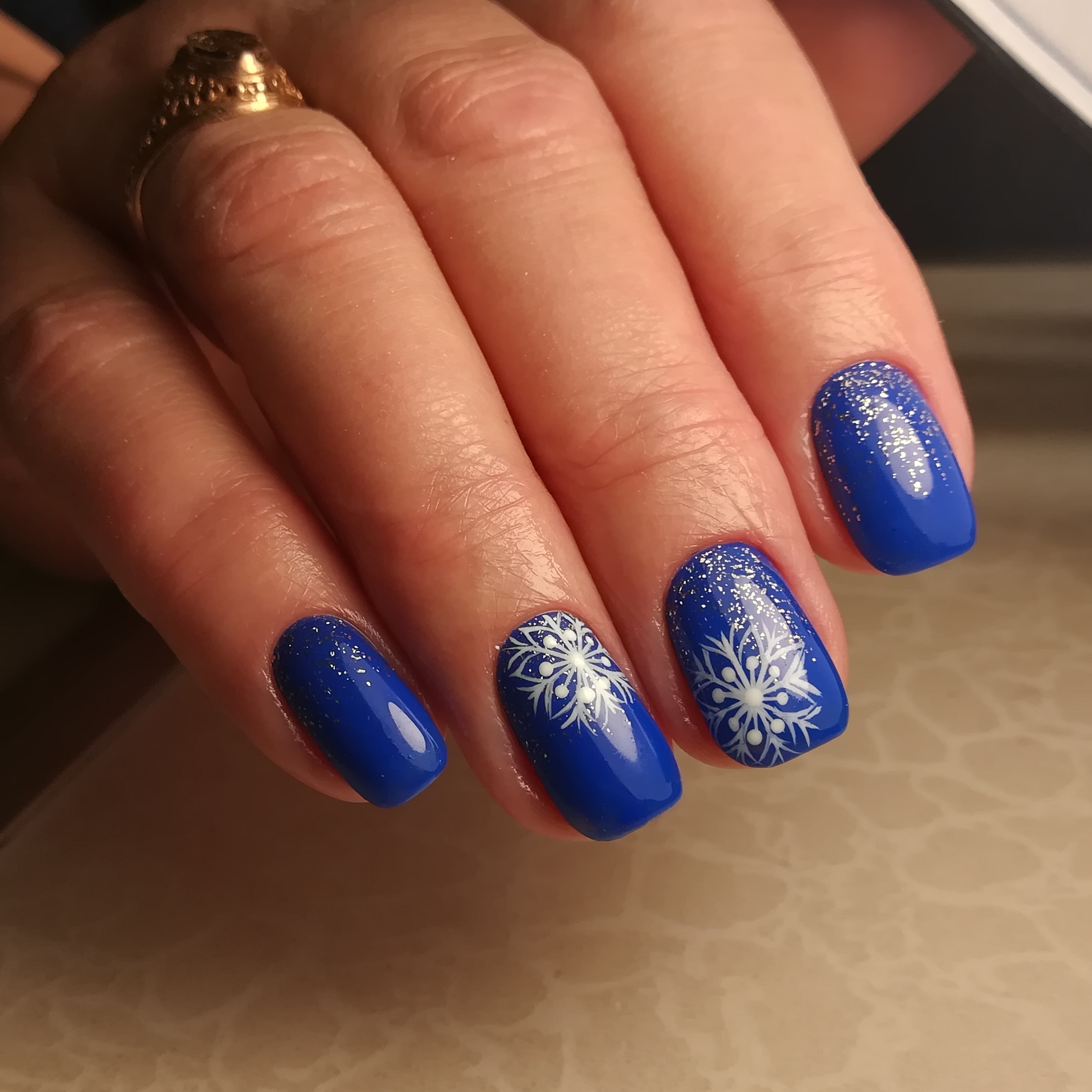 Маникюр со слайдерами "снежинки" и блестками в синем цвете.