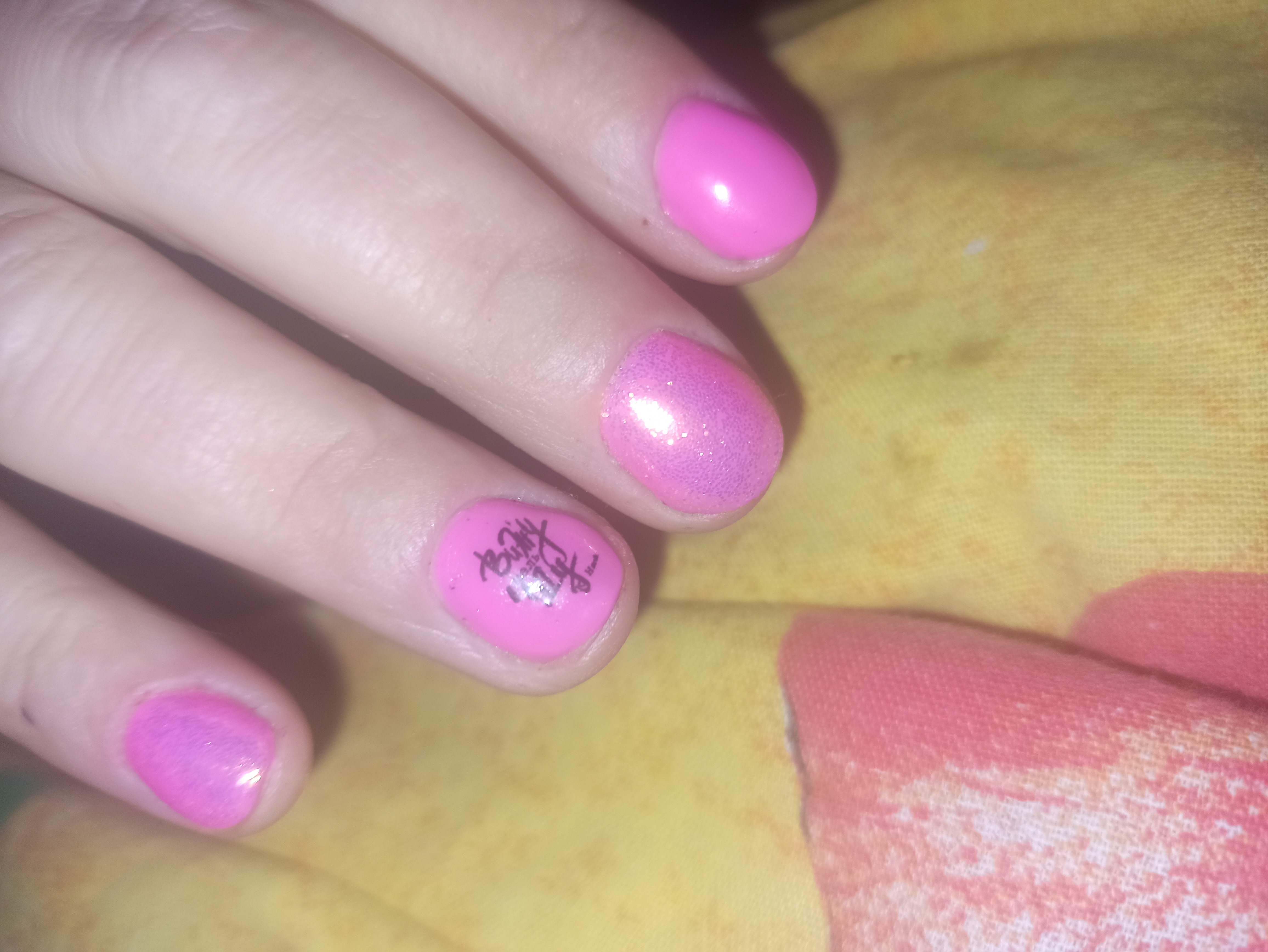 Маникюр с надписями и блестками в розовом цвете на короткие ногти.