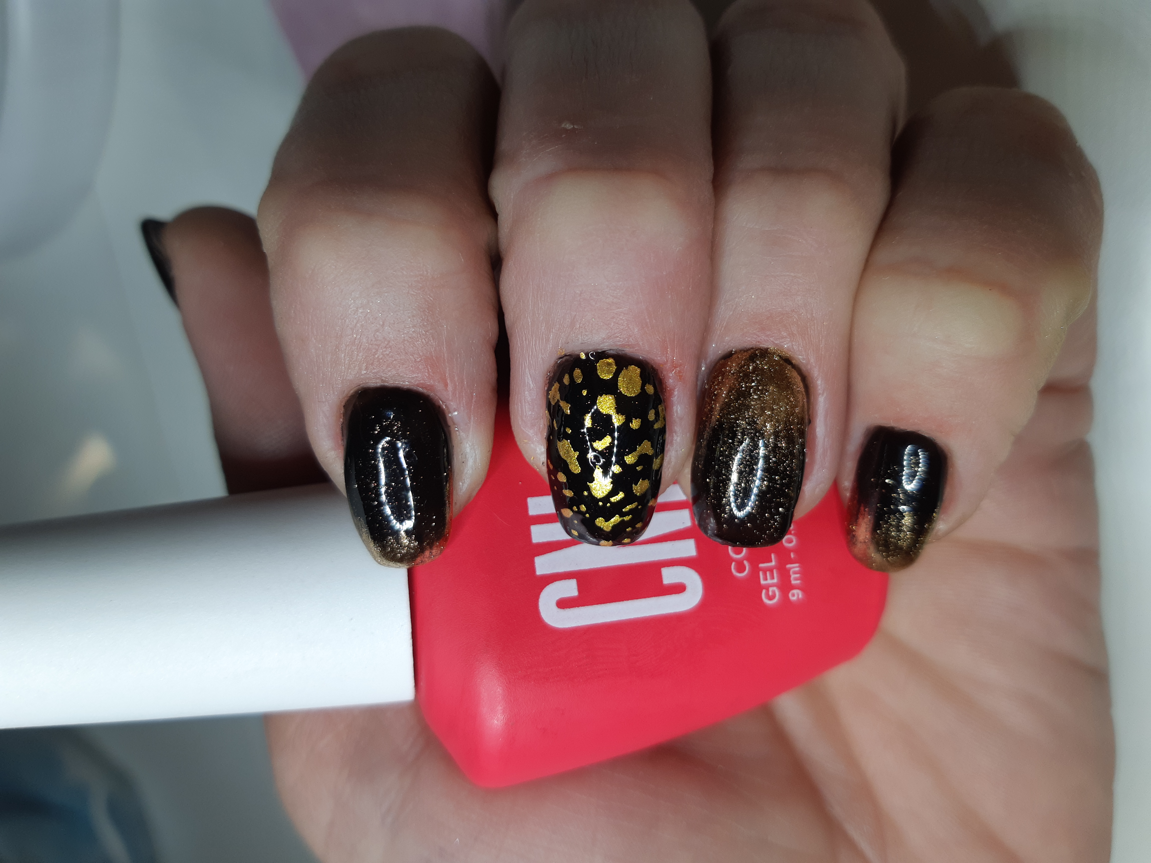 Маникюр с градиентом и золотыми блестками в черном цвете на короткие ногти.