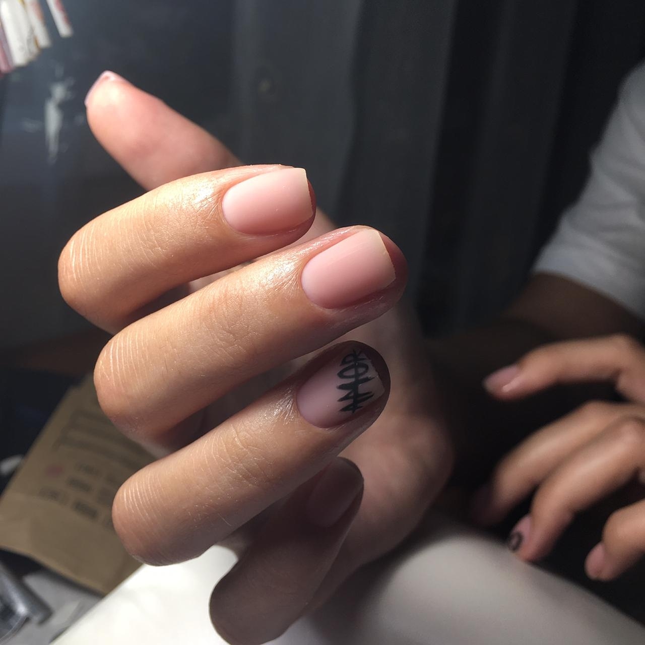 Матовый нюдовый маникюр с надписями на короткие ногти.