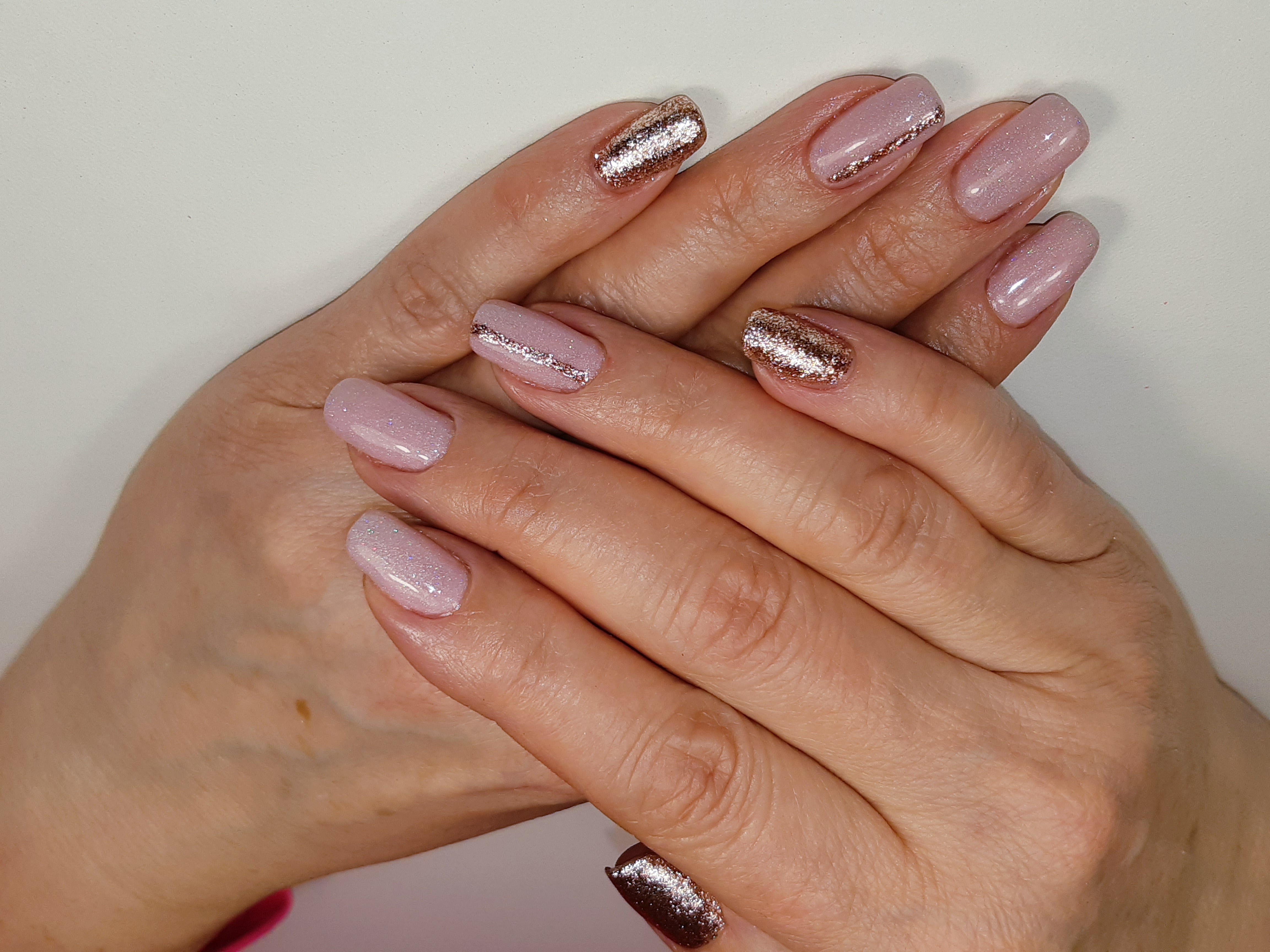 Маникюр с золотыми блестками в розовом цвете на короткие ногти.