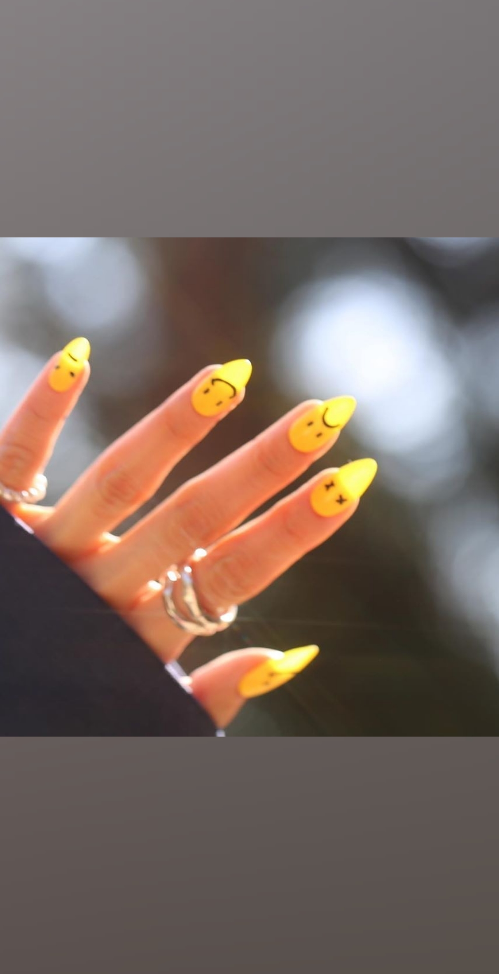 Маникюр со смайликами в желтом цвете на длинные ногти.