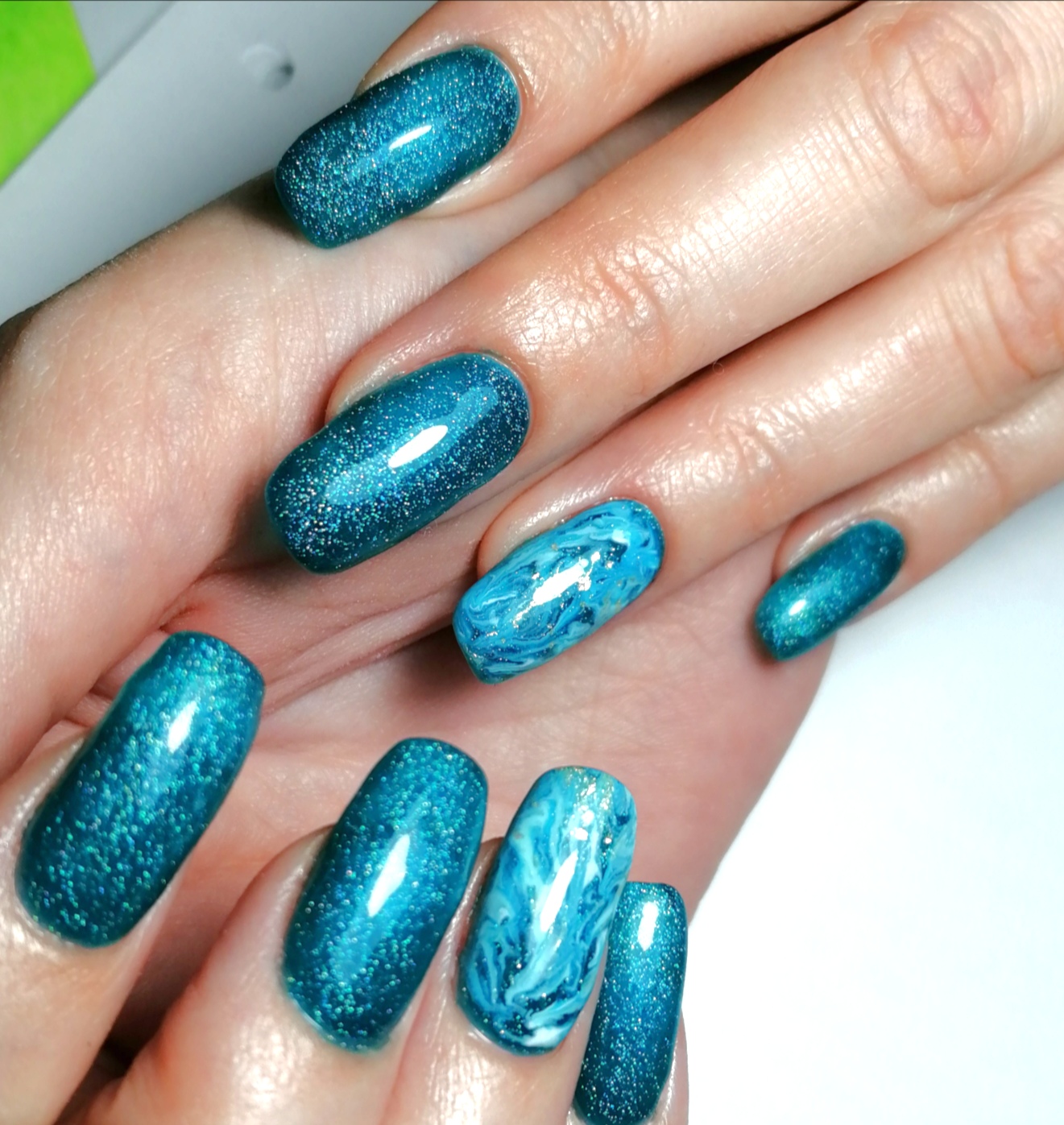Маникюр с морским дизайном и блестками в голубом цвете на длинные ногти.