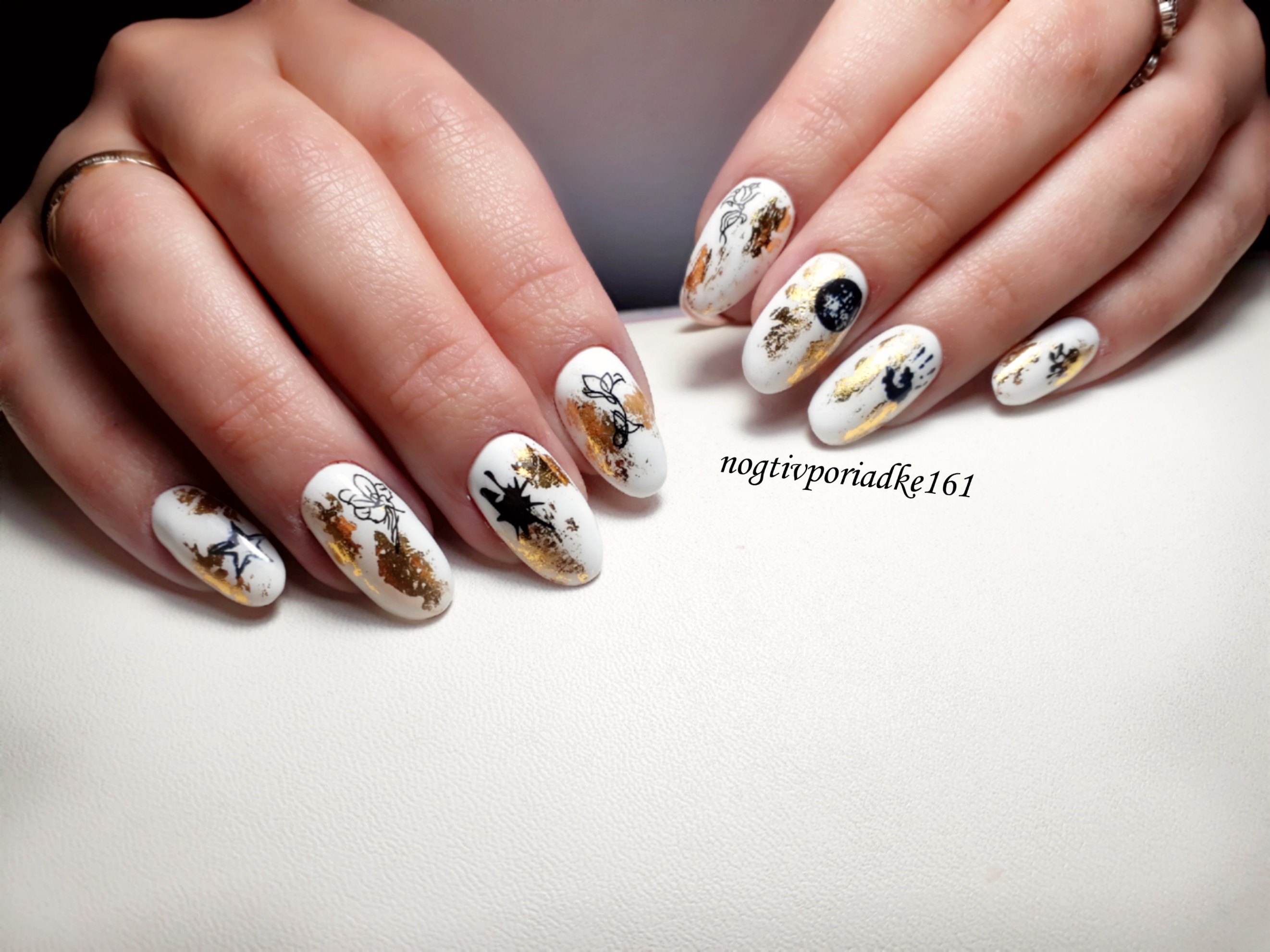 Маникюр со слайдерами и золотой фольгой в белом цвете на длинные ногти.