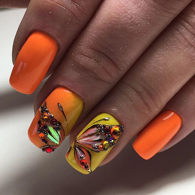 Маникюр с градиентом, бабочкой и стразами в оранжевом цвете.
