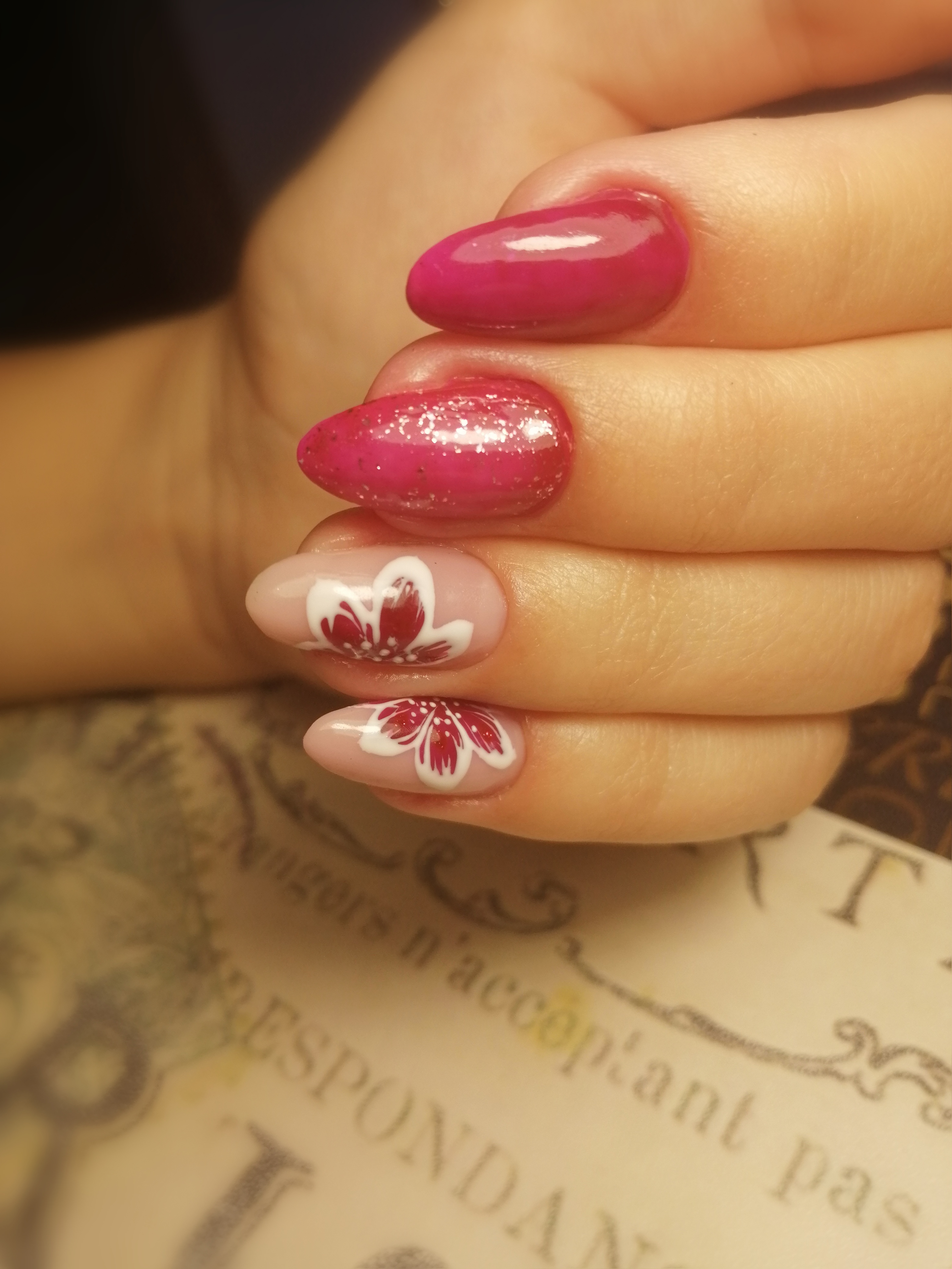 Маникюр с цветочным рисунком и блестками в розовом цвете на длинные ногти.