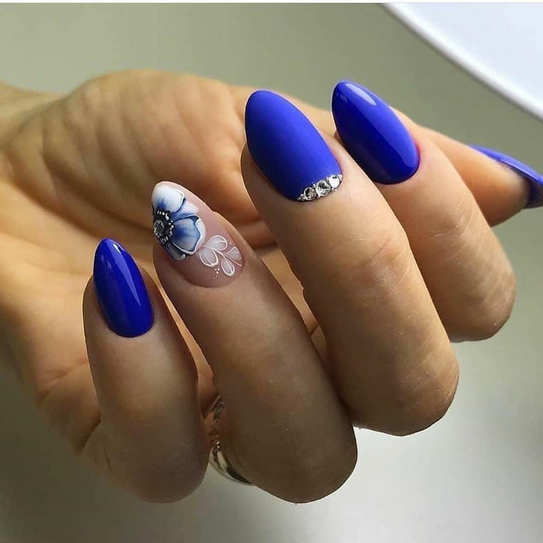 Маникюр с цветочным рисунком и стразами в синем цвете на короткие ногти.