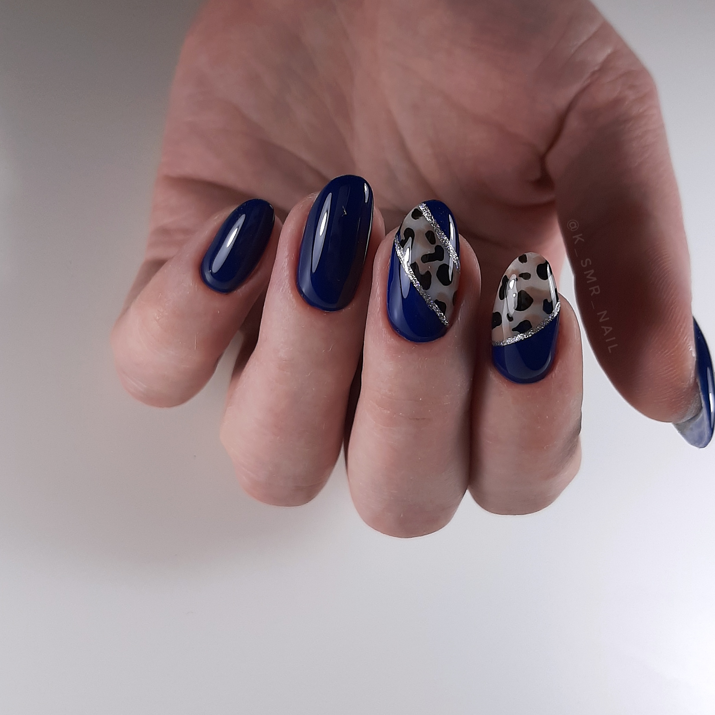 Маникюр с леопардовым принтом и серебряными блестками в темно-синем цвете.