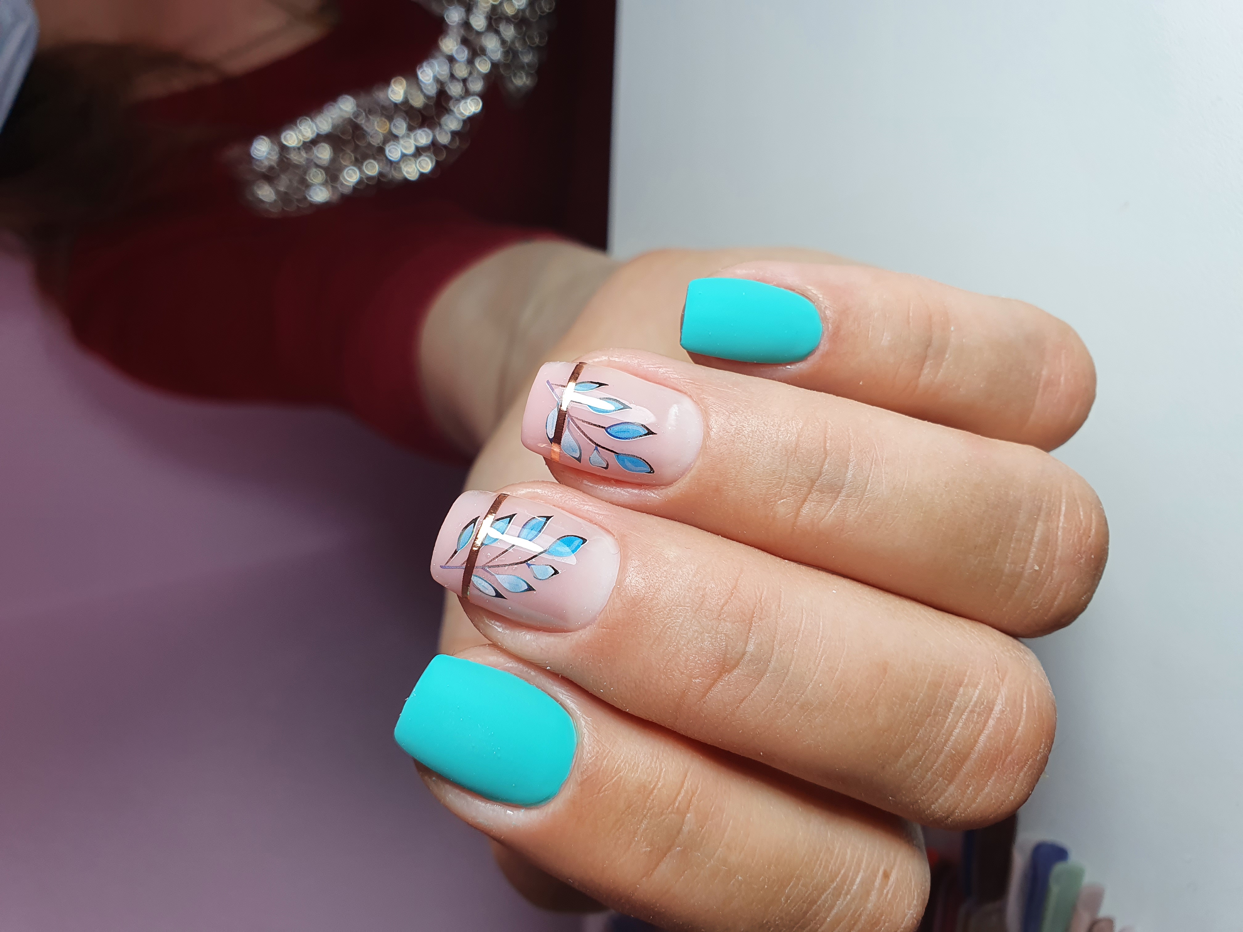 Матовый маникюр с растительными слайдерами в голубом цвете на короткие ногти.