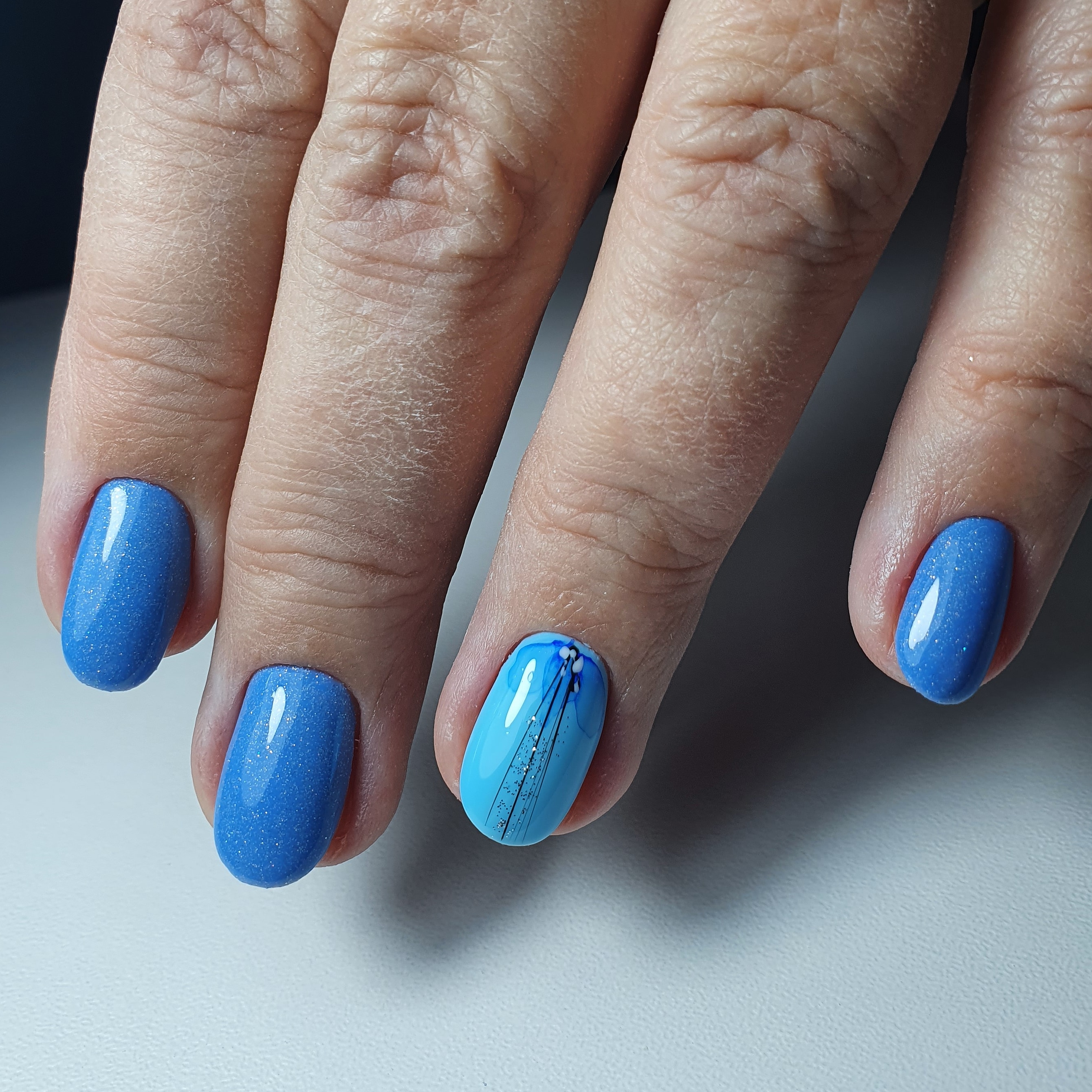 Маникюр с акварельным рисунком в голубом цвете на короткие ногти.
