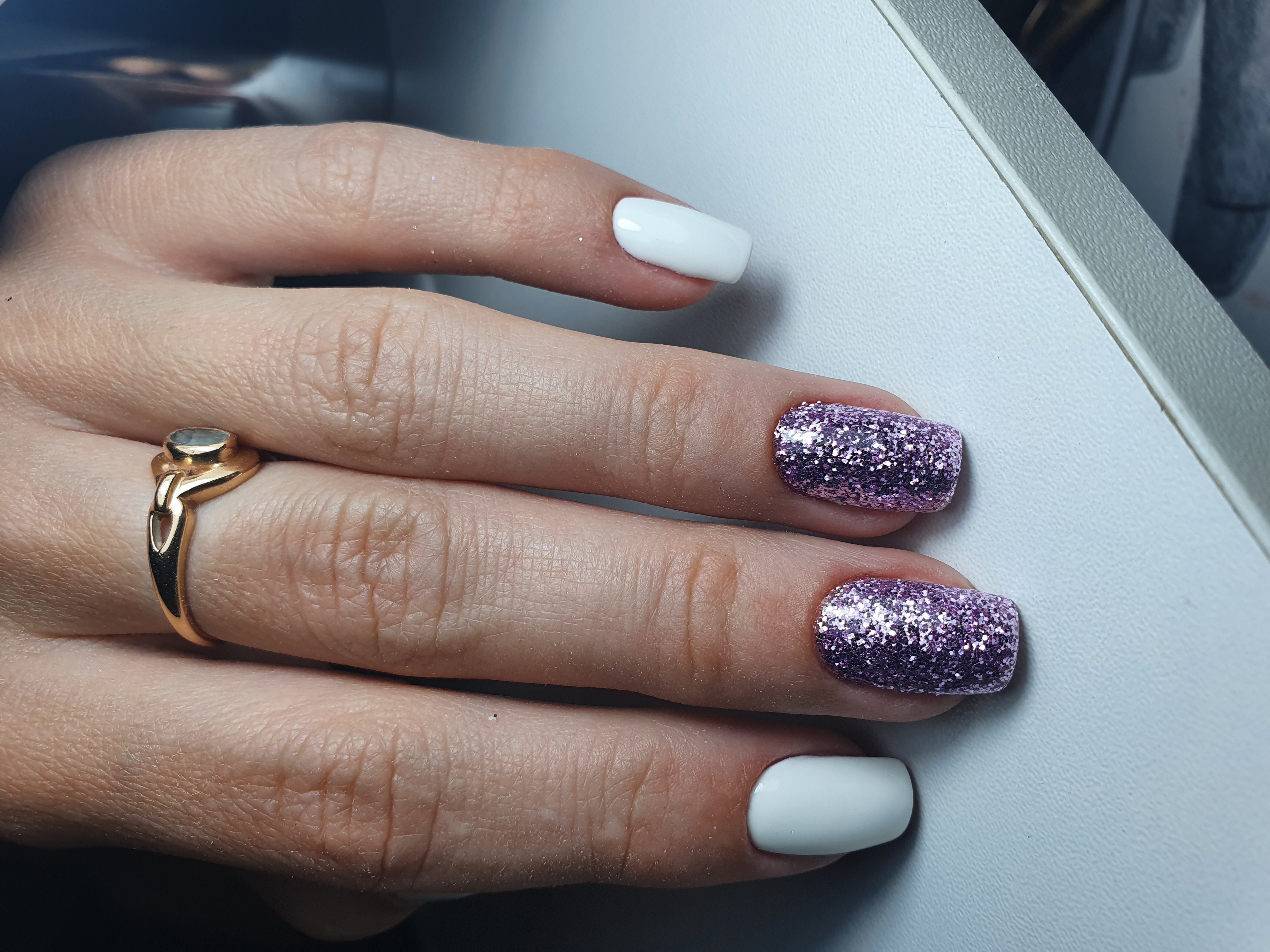 Маникюр с фиолетовыми блестками в белом цвете на короткие ногти.