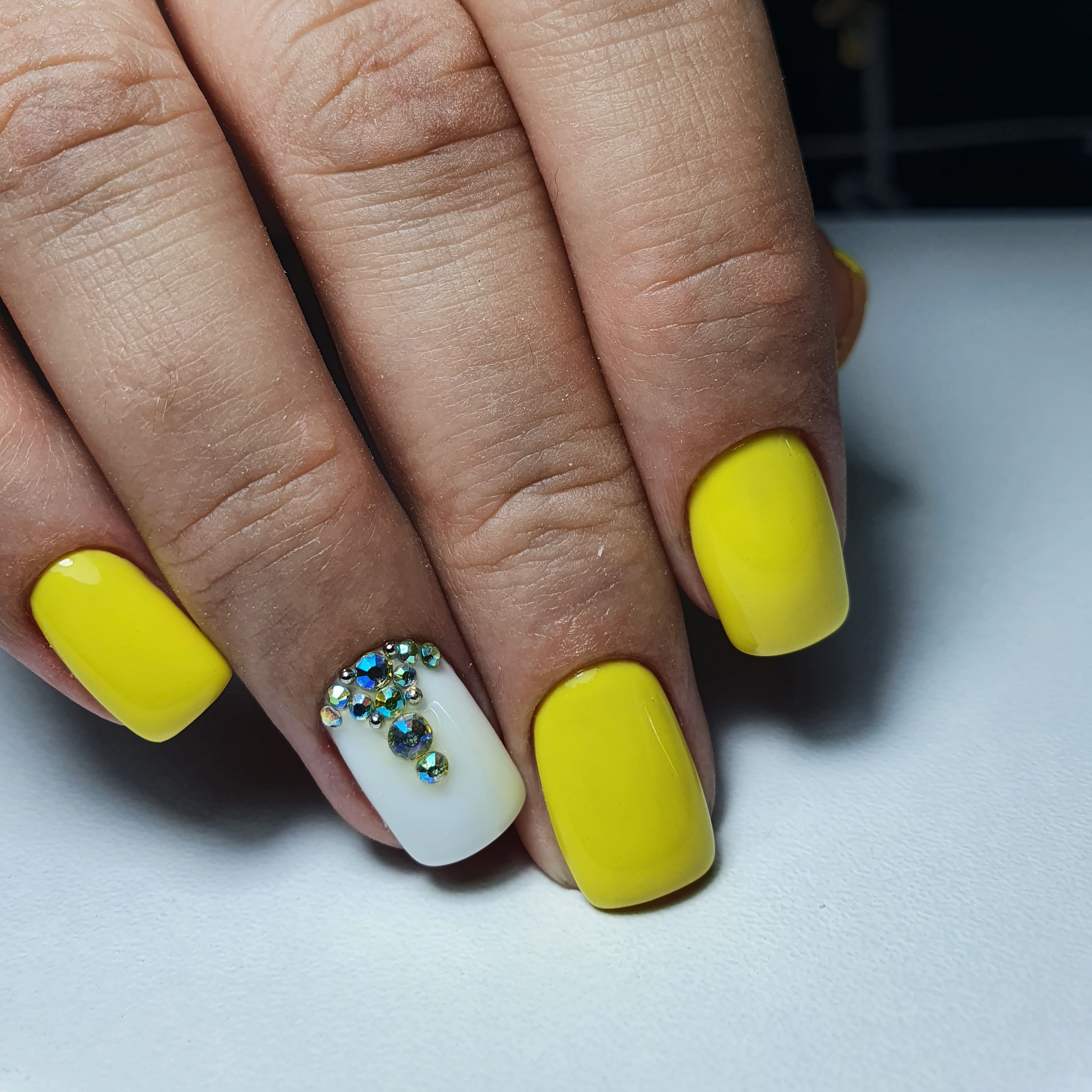 Маникюр со стразами в желтом цвете на короткие ногти.