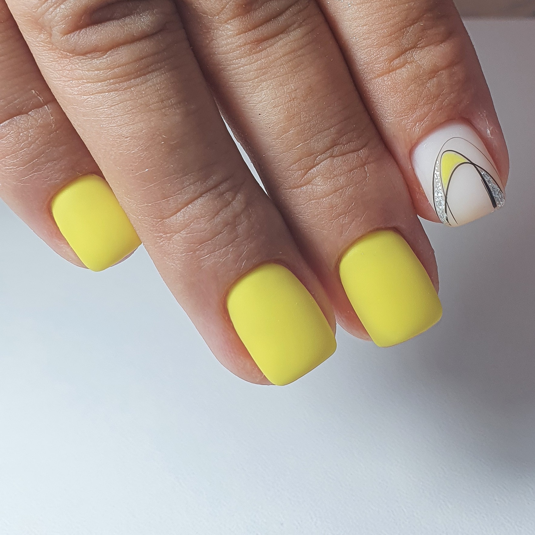 Матовый маникюр с паутинкой и блестками в желтом цвете на короткие ногти.