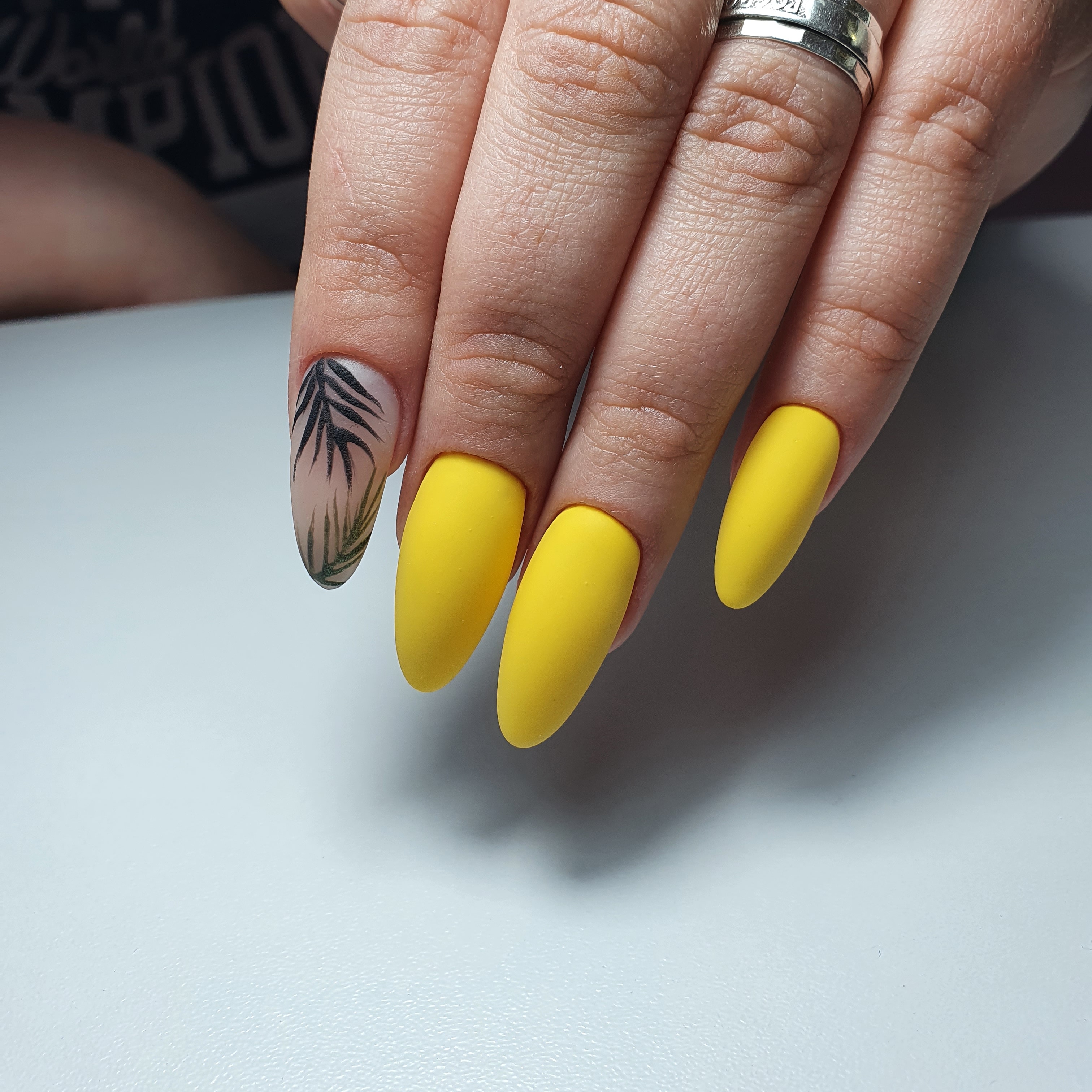 Матовый маникюр с растительным рисунком в желтом цвете на длинные ногти.