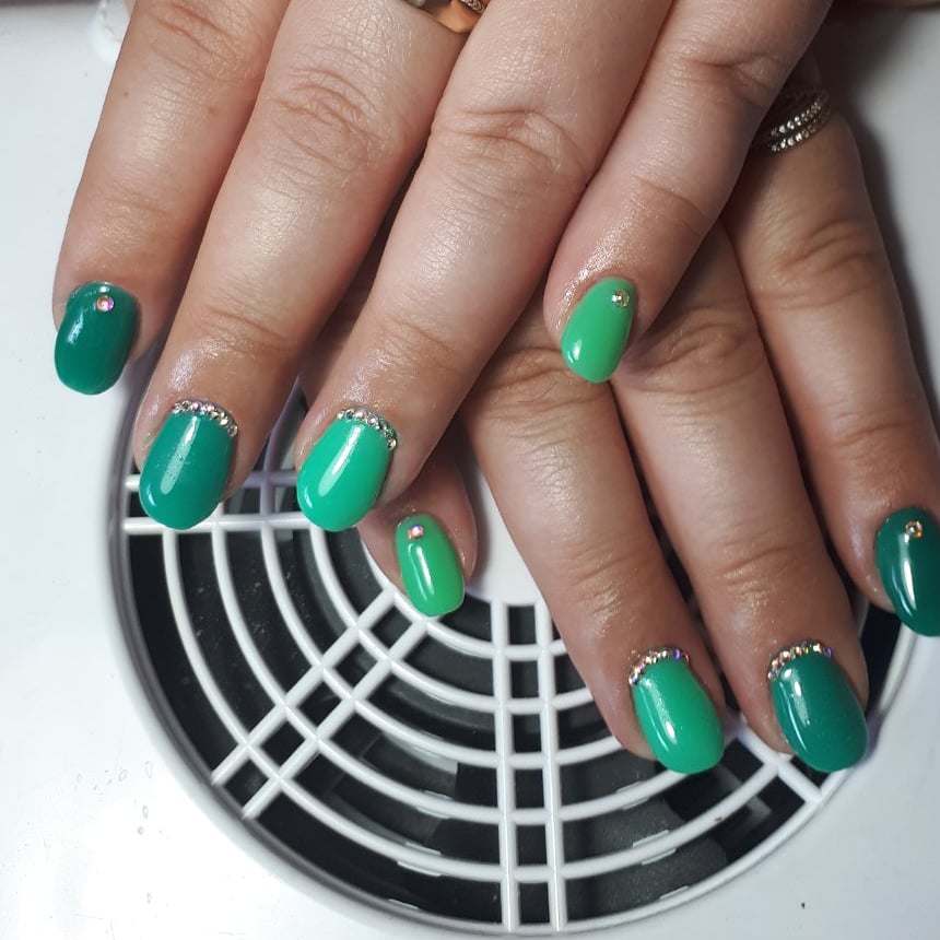 Маникюр со стразами в зеленом цвете на короткие ногти.