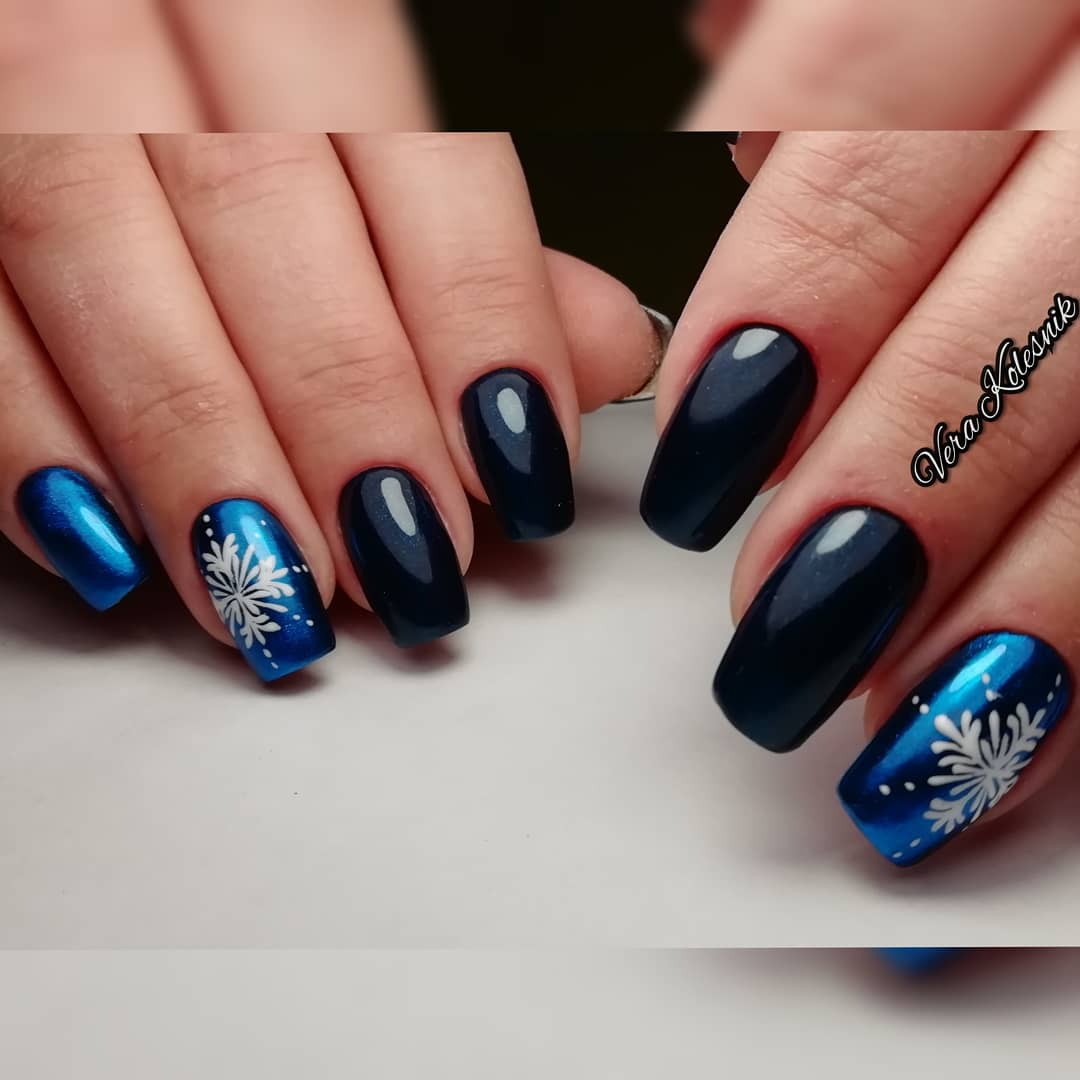 Маникюр с втиркой и снежинками в темно-синем цвете.