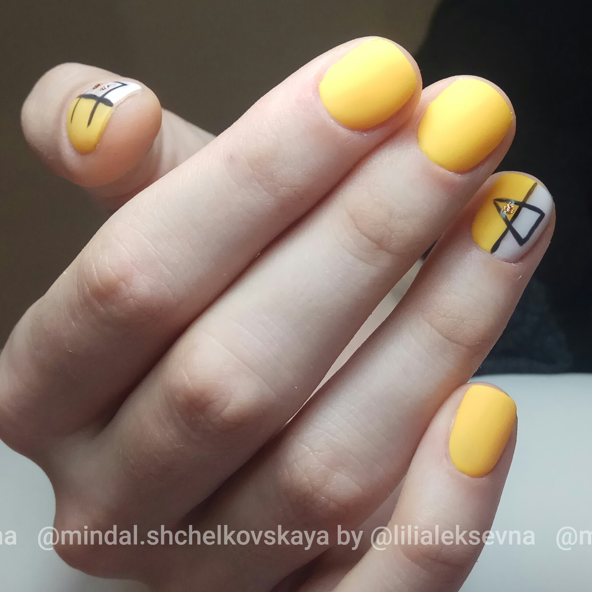 Матовый однотонный маникюр в жёлтом цвете с геометрическим рисунком.
