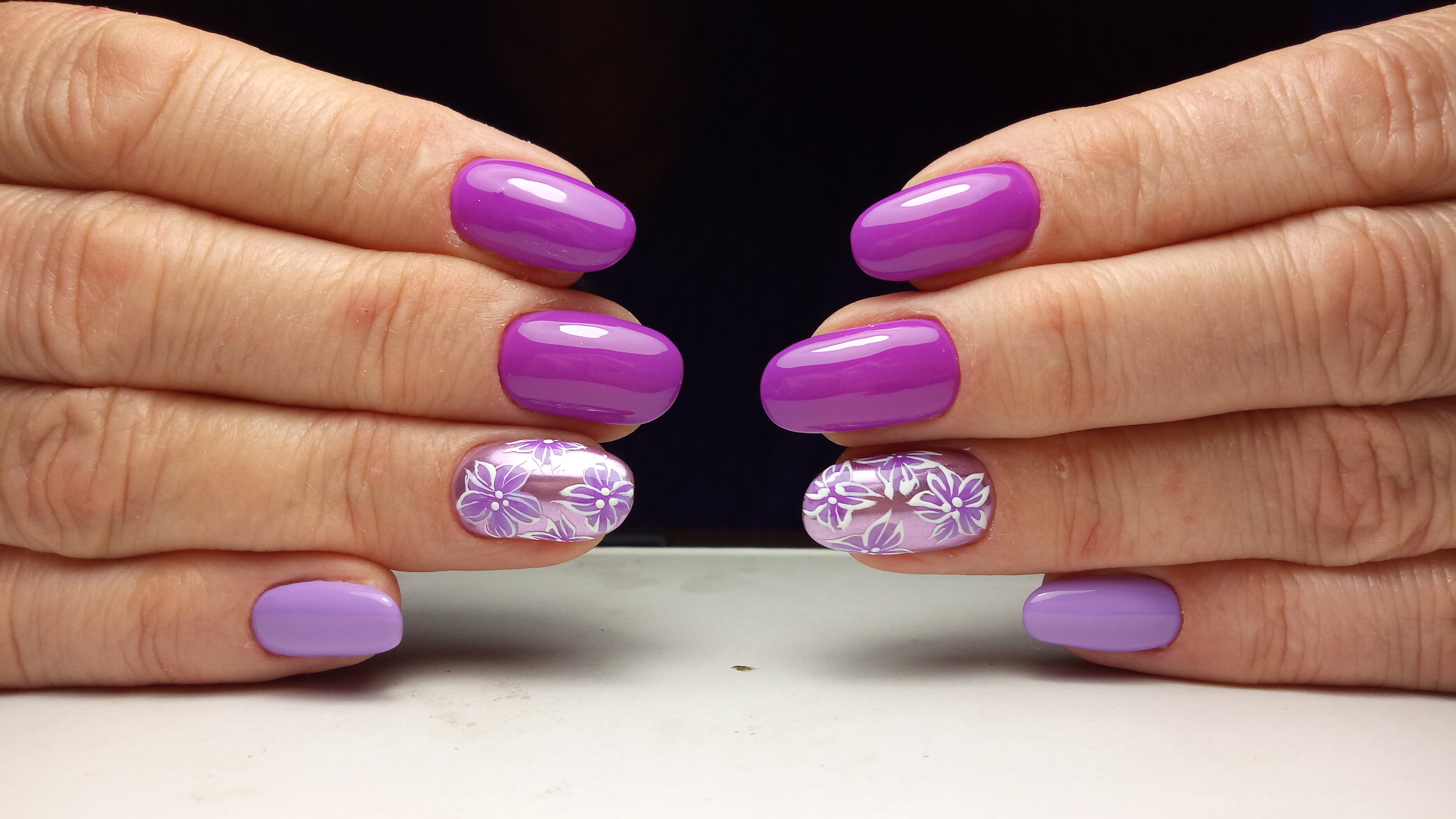 Маникюр в фиолетовом цвете с нежным лиловым дизайном и цветочным рисунком.
