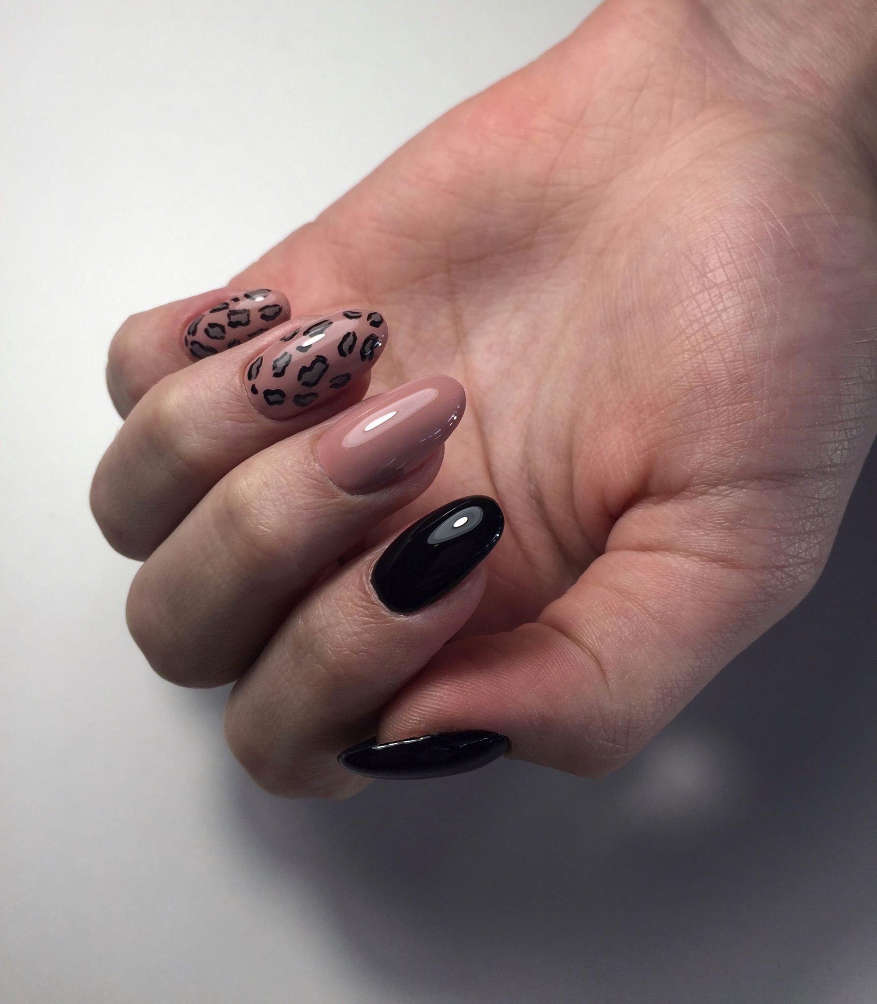 Маникюр с леопардовым принтом в бежевом цвете с черным дизайном.