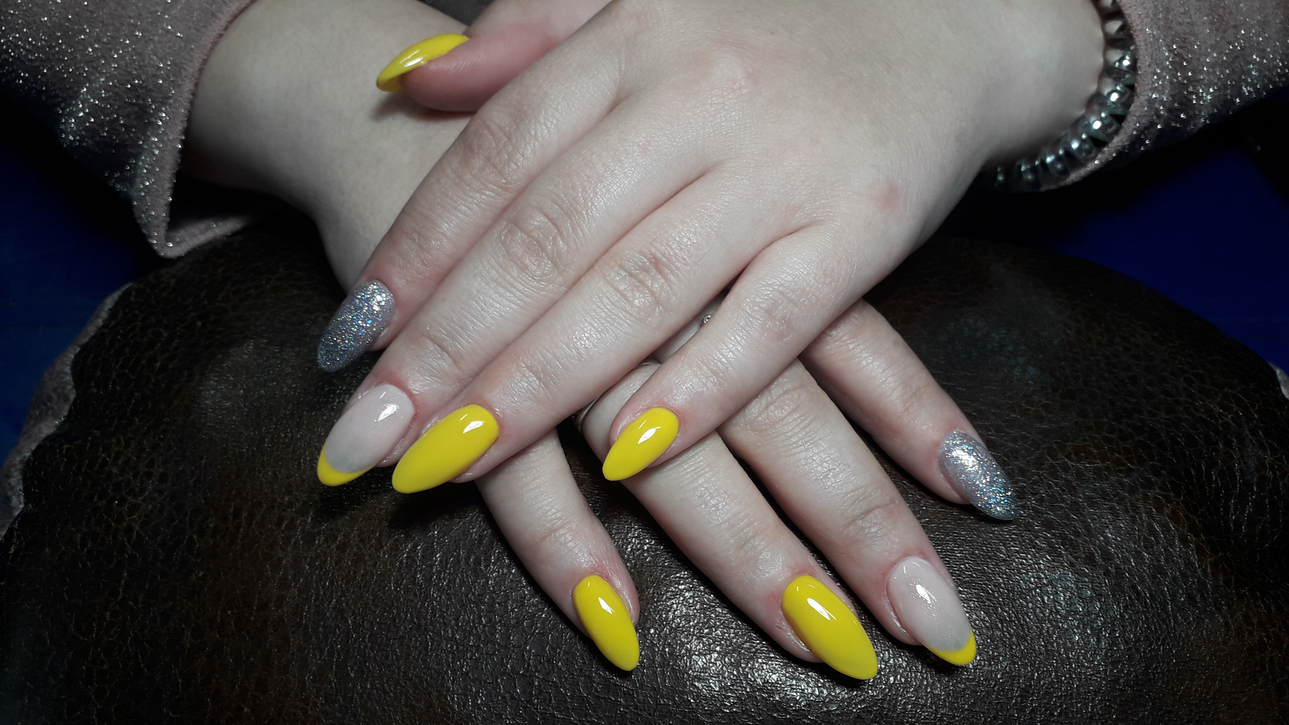 Маникюр с френч-дизайном и серебряными блестками в желтом цвете на длинные ногти.