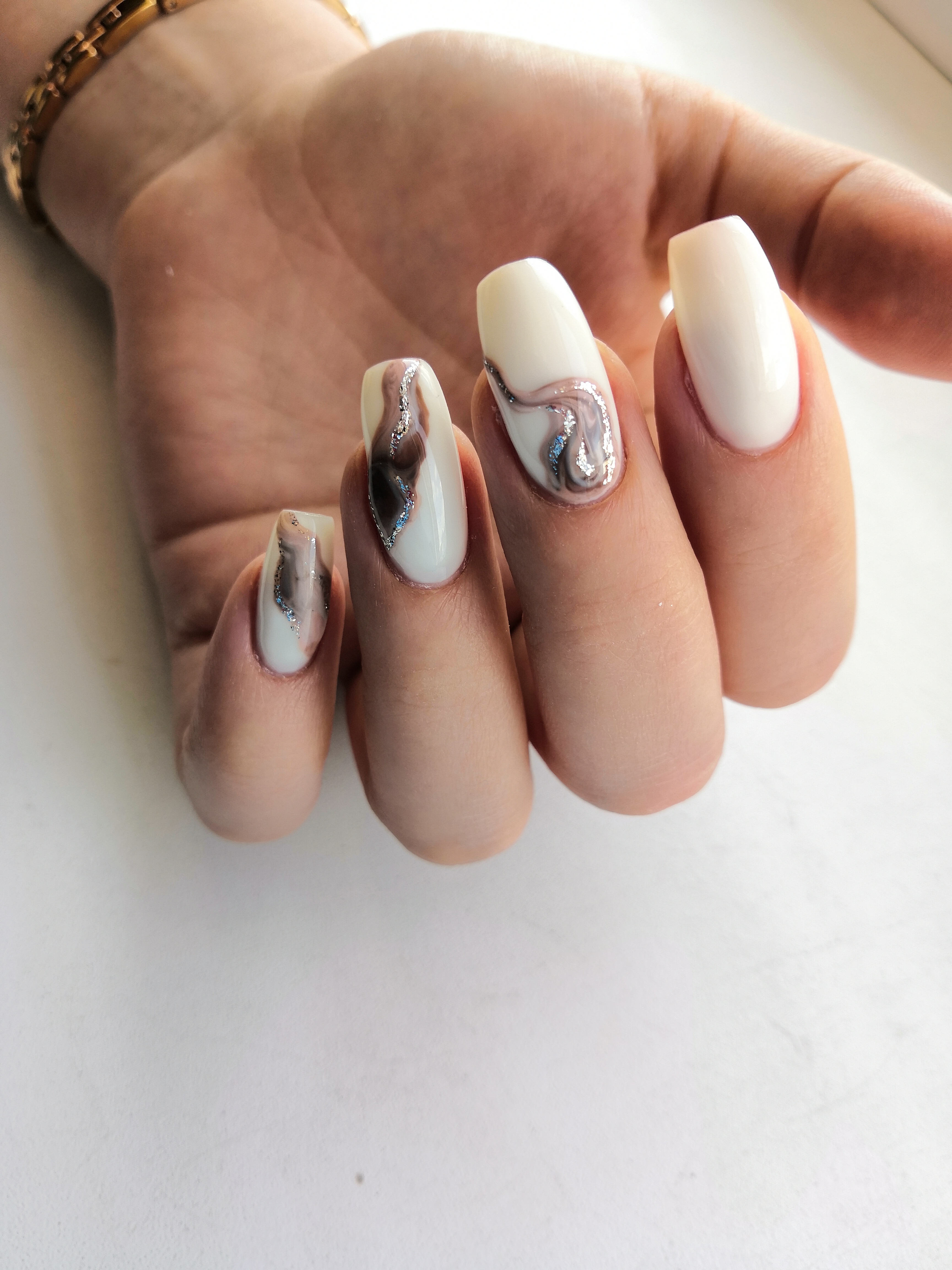 Маникюр с морским дизайном и серебряными блестками в молочном цвете на длинные ногти.