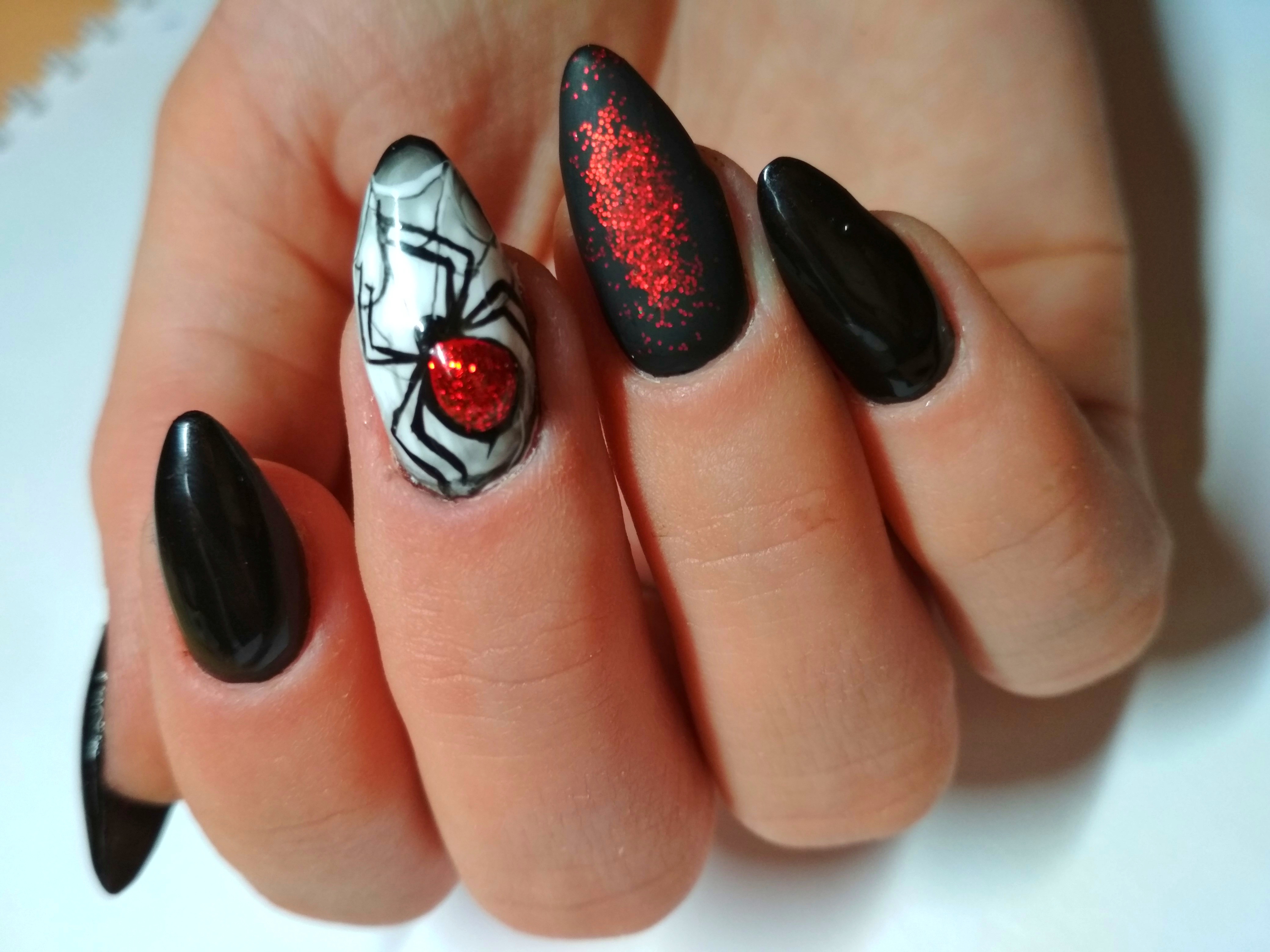 Маникюр в чёрном цвете с рисунком "паук" и красной фольгой.