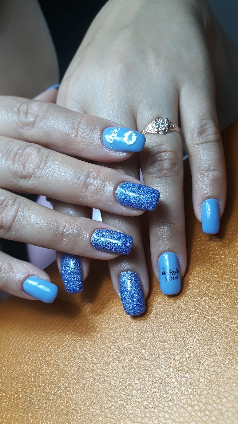 Маникюр с надписями и блестками в голубом цвете на длинные ногти.