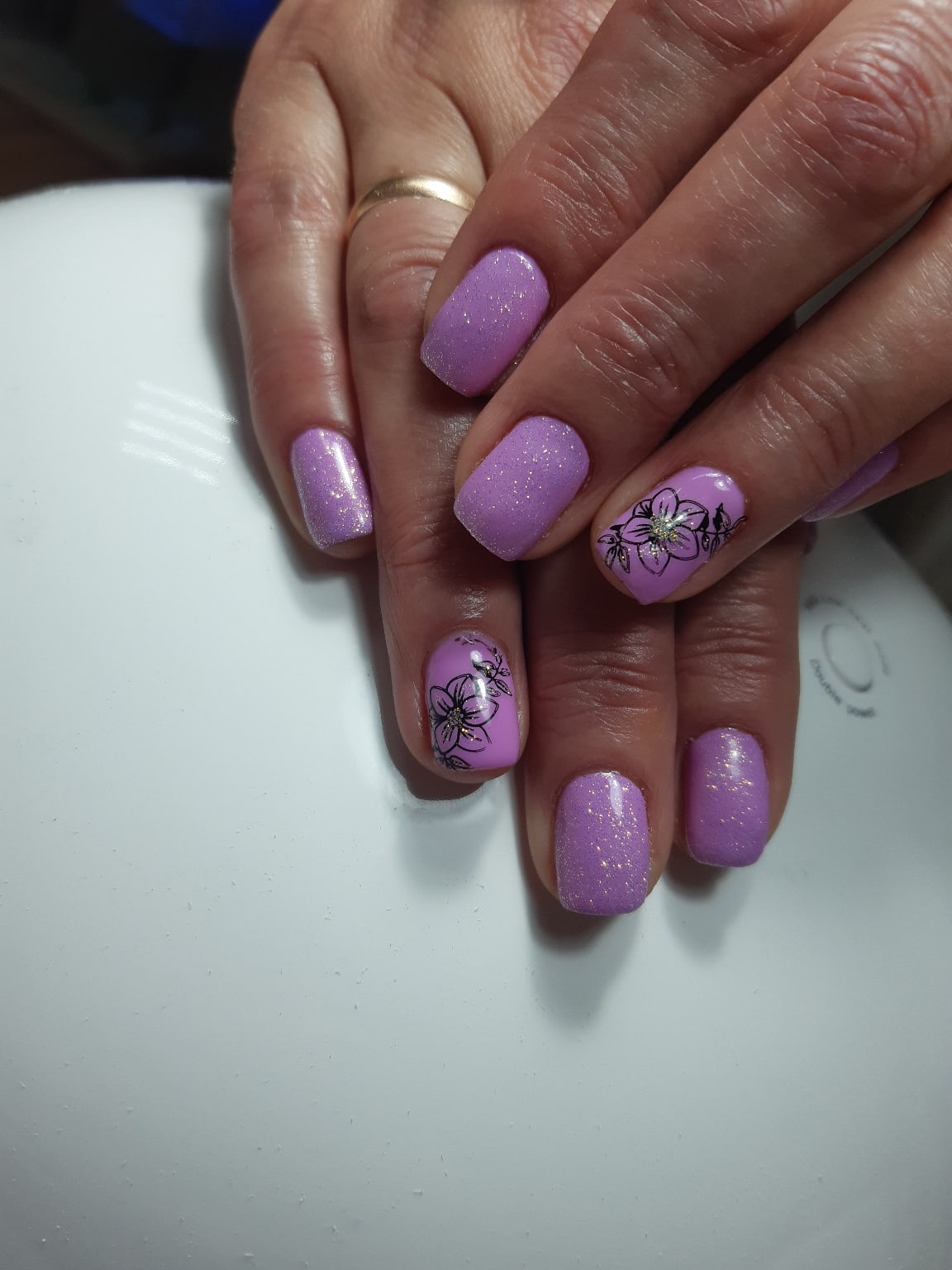 Маникюр с цветочными слайдерами и блестками в сиреневом цвете на короткие ногти.