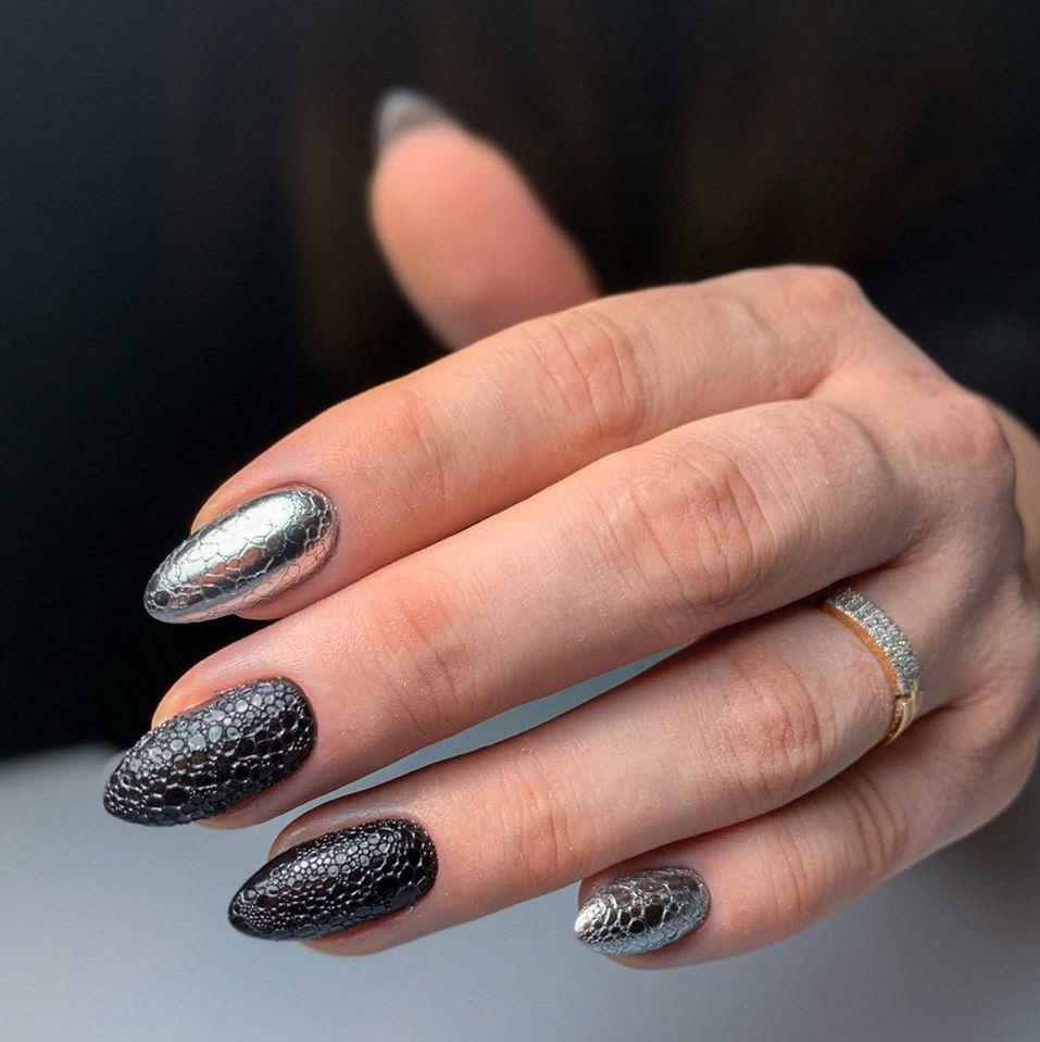 Матовый маникюр с bubble-эффектом и серебряной втиркой в черном цвете на длинные ногти.