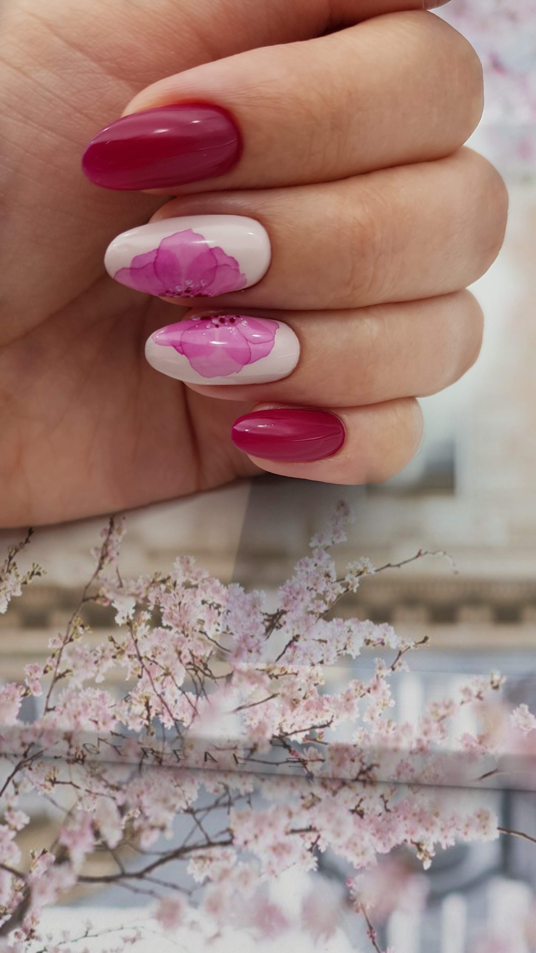 Маникюр с акварельным цветочным рисунком в баклажановом цвете.