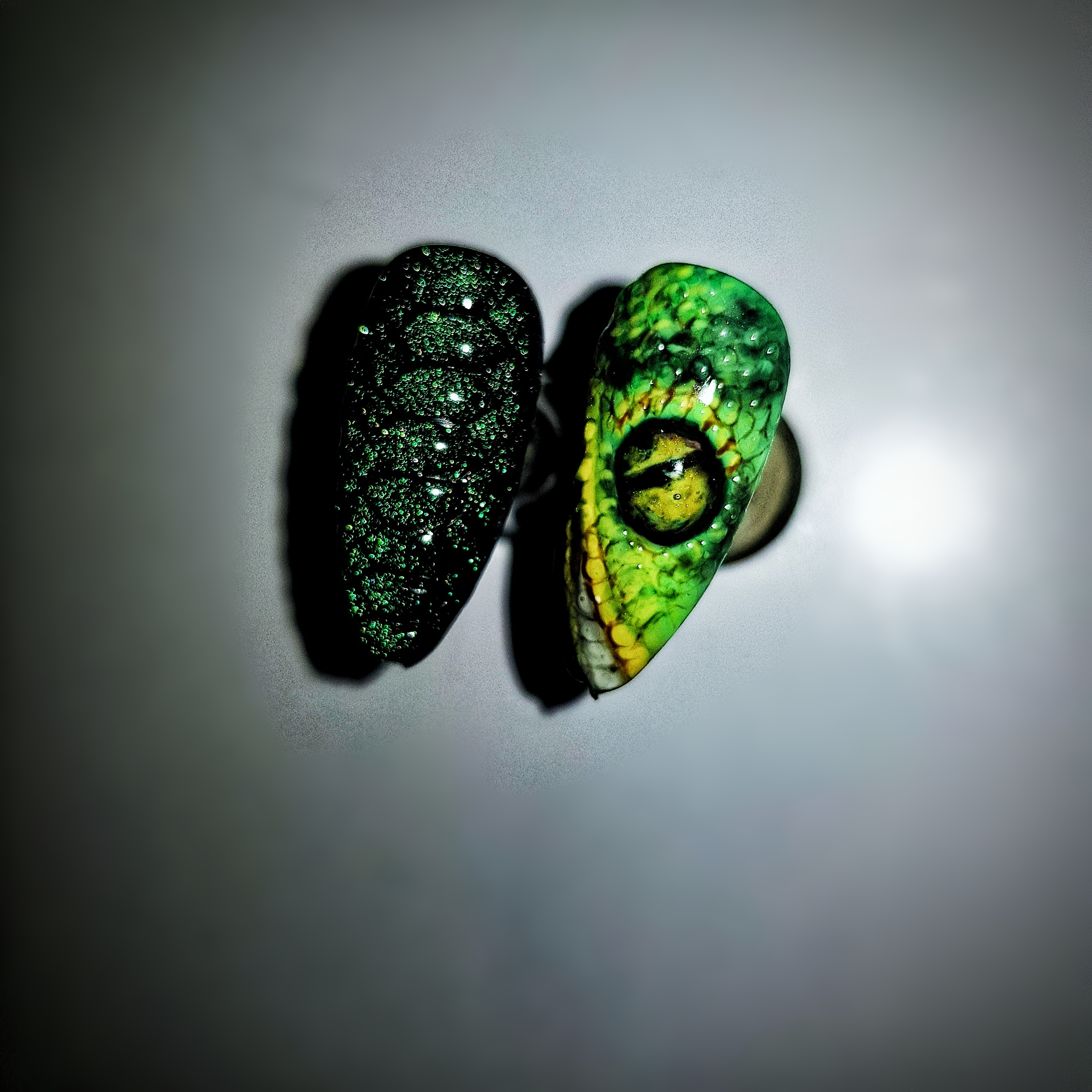Маникюр со змеиным глазом в темно-зеленом цвете.