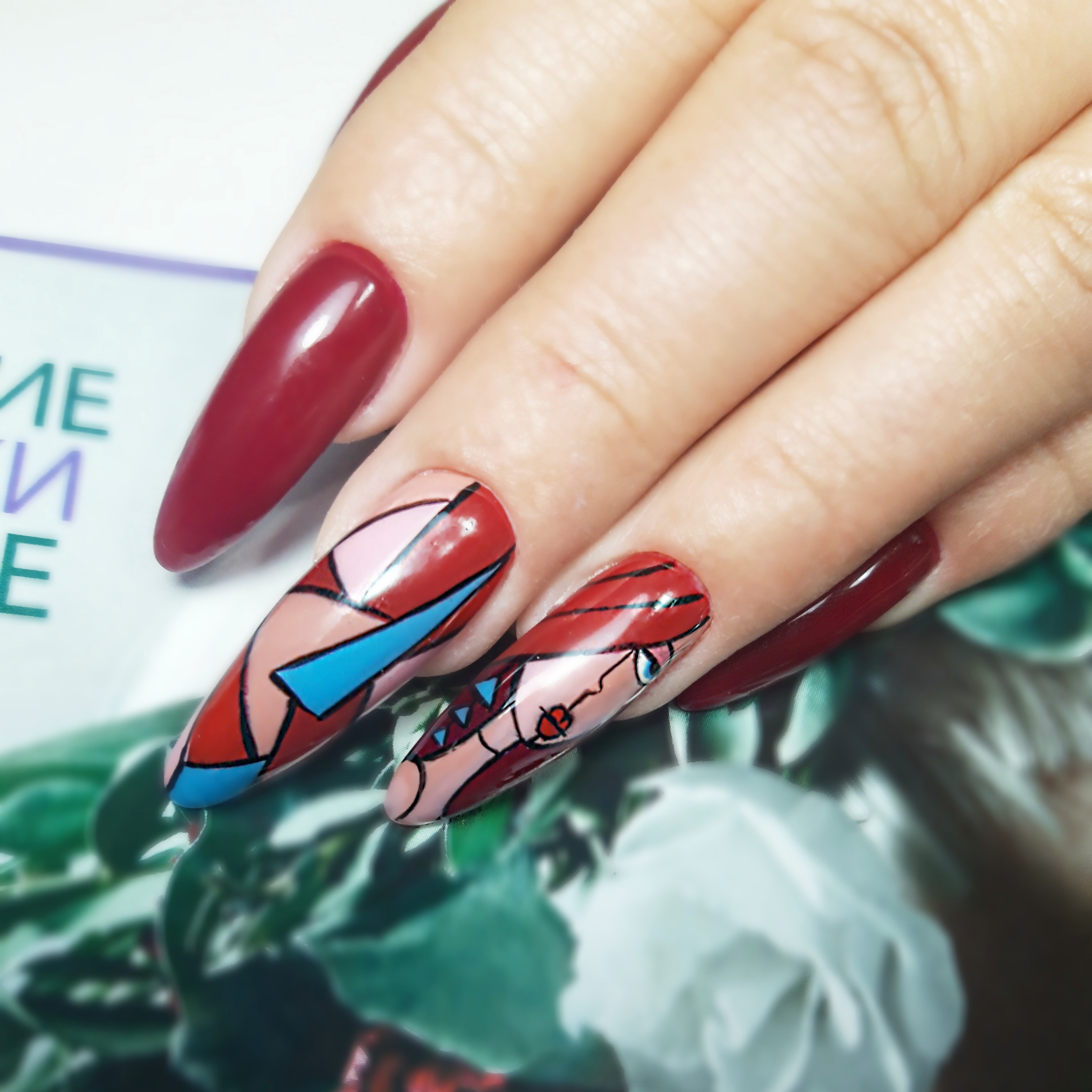 Маникюр с геометрическим рисунком и девушкой в бордовом цвете на длинные ногти.