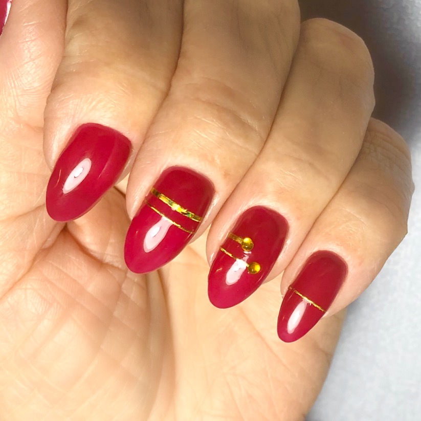 Маникюр с золотыми полосками в бордовом цвете на длинные ногти.